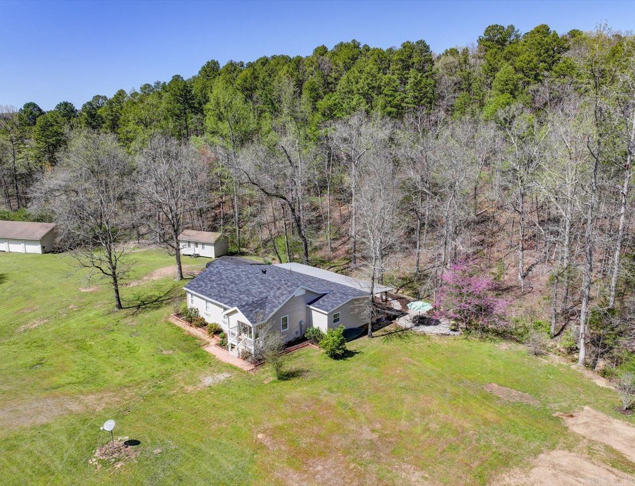 Escape to the tranquility and beauty of the Ouachitas with this charming 3 bed, 3 bath, ranch-style home on 5.78 acres, approx. 4 miles from Brady Mountain Marina and Lake Ouachita. Bordering national forest land, this recently updated home features a 2024 remodeled kitchen w/Quartzite countertops, spacious living areas, and a large covered rear porch with ceiling fans for relaxing in the shade. Outdoors, enjoy a 4-stall garage/workshop, 8'x12' workshop, covered RV and 2 car carport, garden shed & fenced garden spot, and a private well for irrigation and gardening. Freshly painted. New roof, water heater, disposal and ceiling fans in 2024. Whether you're looking for a serene full-time residence or a weekend getaway, this property offers space, privacy, and incredible access to outdoor adventure.