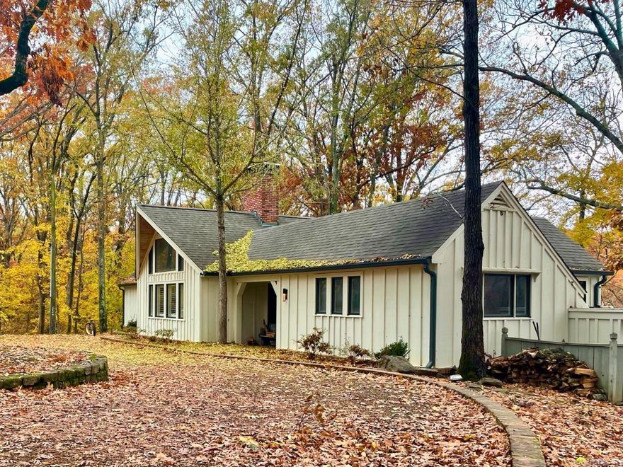 Welcome to your treehouse home! This stunning and serene mid-century home is located in the quiet, wooded Edgewood neighborhood. Nestled on a generous lot, with upper lake access and sweeping views through the trees, this residence surrounds you with natural beauty. The large wood-burning fireplace, located between the kitchen and den, is the heart of the home. Imagine gazing into the beautiful fall foliage next to a glowing fire! The adjacent kitchen is both charming and functional, complete with lovely granite countertops and ample cabinet space. This home offers three spacious bedrooms and two well-appointed bathrooms. The primary bedroom has especially beautiful views, and with glowing hardwood floors and updated fixtures, the home maintains a modern, elegant appeal. The recently painted exterior adds to the home's curb appeal, but you’ll enjoy plenty of peace and privacy situated on a private dead-end street. Don't miss the opportunity to own this exceptional home that combines modern living with the beauty of nature. It's more than a home; it's a lifestyle.