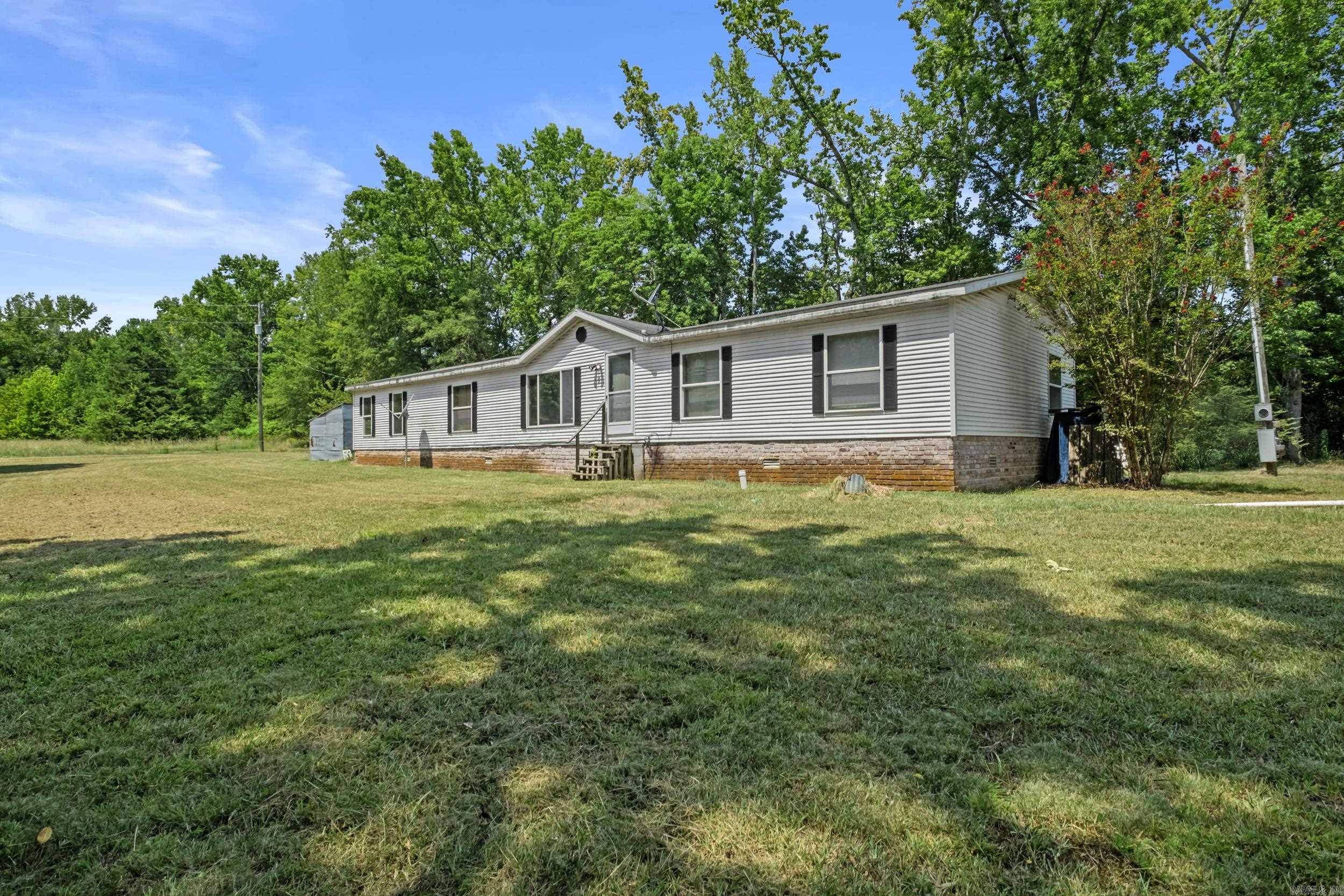 Come check out this spacious Mobile home on +/-5 Acres! It's 20 x 30 with 4 bedrooms, 2.5 baths, and a seperate shop! Kitchen appliances are NEW and convey! Property is on a permanent foundation and has septic. New carpet in the primary suite. Property is clean and move-in ready. *Sold As-IS* * Adjacent +/- 5 acre lot (with seperate septic) is also for sale. Ask selling agent for more info*
