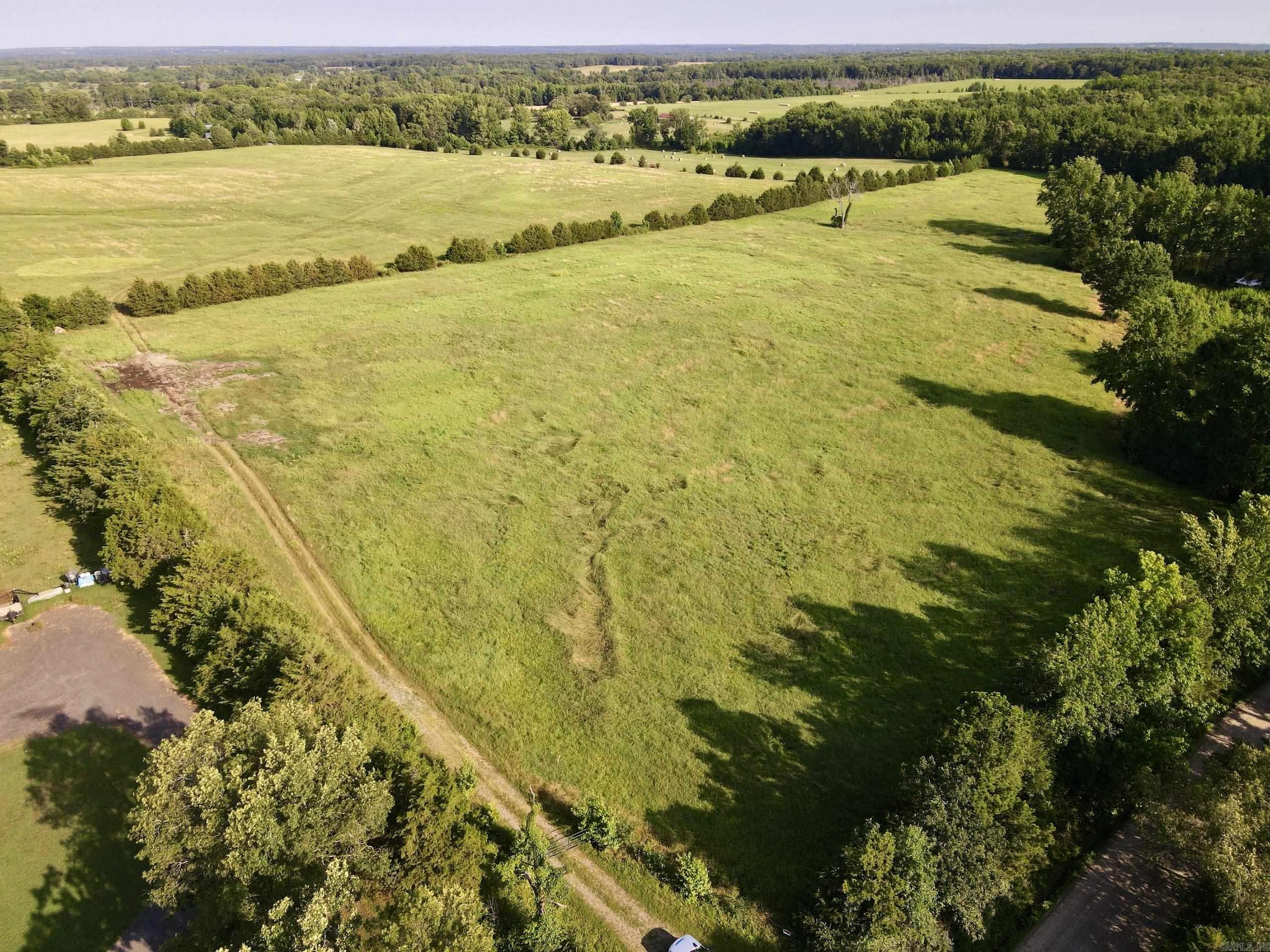 This property is a hay producer's dream with 120 acres of meticulously maintained hay ground, soil-tested bi-yearly, and fertilized up to three times a year which produces about 1500 bales annually. The farm is fully fenced and cross-fenced, ensuring optimal land management. A spacious hay barn, secure storage container, and a deep well enhance the farm's functionality. Located in a very desirable location you may want to build your family home or convert the property into a beautiful highly productive horse or cattle operation. This exceptional 127-acre farm also features two stocked catfish ponds and a bass pond. Don't miss this unique opportunity to own a well-equipped and productive farm.