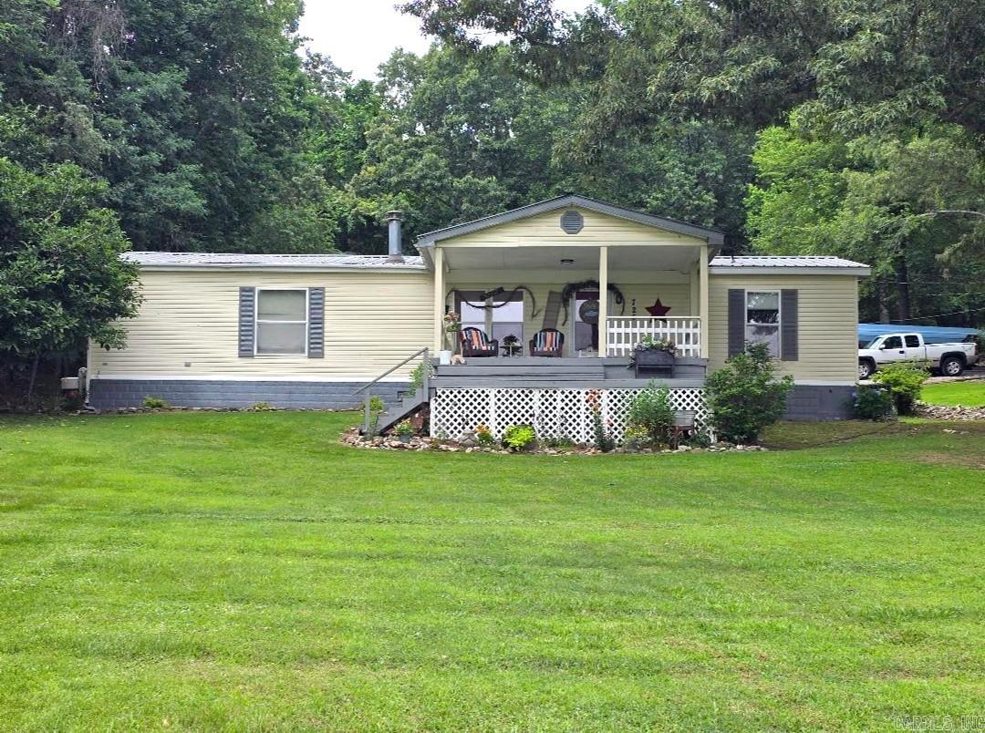 Enjoy being home in this peaceful rural setting! Included are two homes and hookups for a third. Homes sit on a 1.68 acre lot with beautiful shade trees, flower beds & shrubbery already there and only minutes from town. The 1680 sq ft double wide was custom built with hardwood flooring in living room, 6'' outside walls, plywood subfloors & plywood wrapped exterior w/ vinyl siding and consists of 2 beds/2 baths and a huge open living area that includes a cozy breakfast nook and roomy dining area. New kitchen cabinets were added a few years back. Enjoy sitting on the big front porch or the relaxing on the large back deck. There is a double carport, work shed, and two outbuildings on property. The smaller mobile has 2 beds/1 bath, and the kitchen was updated in 2021-22. It has a relaxing front porch as well. This property could offer multiple options.