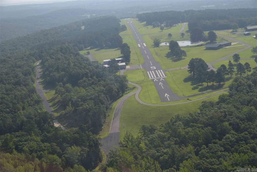 Located on the runway, this lot is the best of all worlds - a cleared area for your home and hangar, and a nice wooded area on the north side of the lot. Holley Mountain Airpark is a premier airpark nestled in the Ozark Mountains of Arkansas. Paved 4,800 x 50 foot paved runway, complete with two GPS approaches and pilot controlled lighting. Gated community. Close to hiking, mountain biking and ATV trails, golf courses and Greers Ferry Lake.Just a few hours from Branson & just over an hour from Little Rock