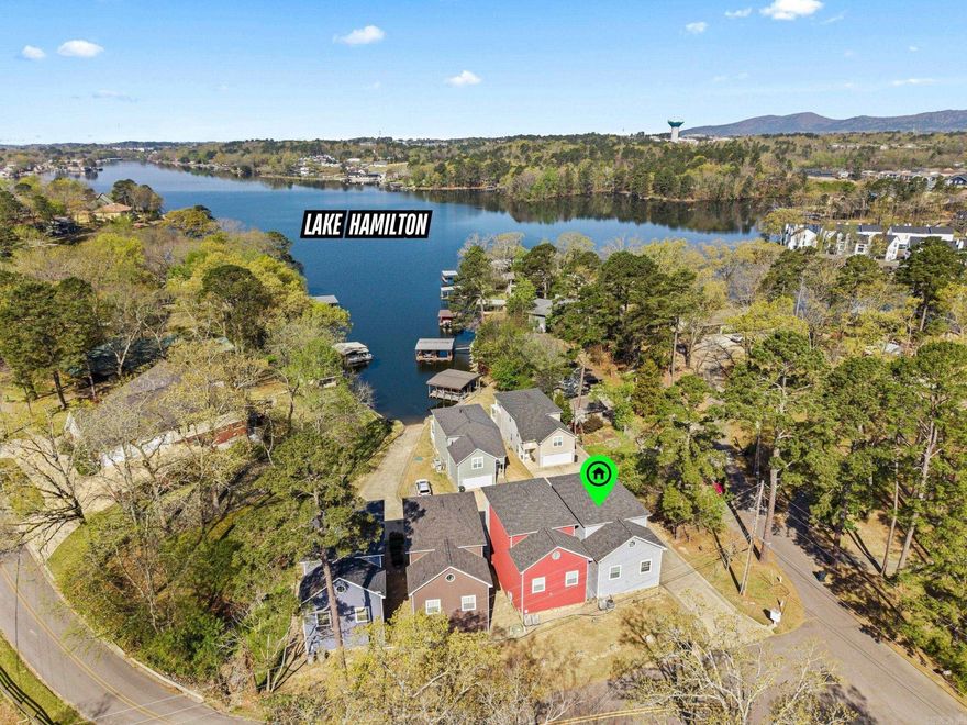 Unpack your bags and experience Lake Hamilton living in this rare 3BR/2BA home! Located in an exclusive enclave of just 6 homes, this fully furnished retreat offers the ultimate low-maintenance lifestyle. The HOA covers exterior yard care, and upkeep of the community boardwalk—complete with water tie-offs for your boat and a private boat ramp. Inside, enjoy an airy open-concept layout boasting designer finishes: luxury vinyl plank flooring, stunning quartz countertops, and spa-like bathrooms. Step outside to two large decks perfect for entertaining and soaking in the lake views. A massive oversized garage easily accommodates your boat trailer and water toys! This would make a wonderful low stress vacation home or your home base Lakehouse!  All furniture is included in the sale. Mechanical Peace of Mind: New roof (2023) and a high-efficiency HVAC system (2022) deck fully replaced and stained with IR Reflective stain (2025) Located within a short drive to historic downtown, Oaklawn racing, shopping and restaurants this home represents a rare lifestyle upgrade. Come enjoy all Hot Springs has to offer. Agents see remarks.