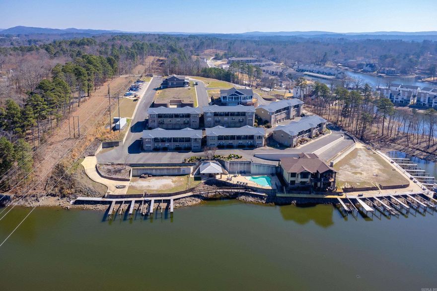 Luxury Lakefront Living at 620 Grand Point #25B, Hot Springs, Arkansas. Experience refined lakefront living in this beautifully appointed 3-bedroom, 2.5-bath condo offering 2,393 square feet of thoughtfully designed space. Located within the private, gated community of Lighthouse Point HPR, this exceptional residence is positioned along the waterfront row and is being sold fully furnished, making it truly move-in ready. The main living area and primary suite are located upstairs, featuring an open-concept design for ideal entertaining, along with a convenient half bath. Downstairs, you'll find two additional bedrooms and a half bath, including custom-built queen bunk beds that maximize both comfort and functionality. Separate entrances for the upper and lower levels provide added privacy and flexibility. Recent upgrades include fresh paint and luxury vinyl-plank flooring throughout (2021), granite countertops (2021), and new windows in the primary bedroom (2021). Enjoy effortless lake access with your own 10' x 30' boat slip, perfect for boating days on Lake Hamilton. This is a rare opportunity to own a luxury, furnished condo in one of Hot Springs' most desirable settings.