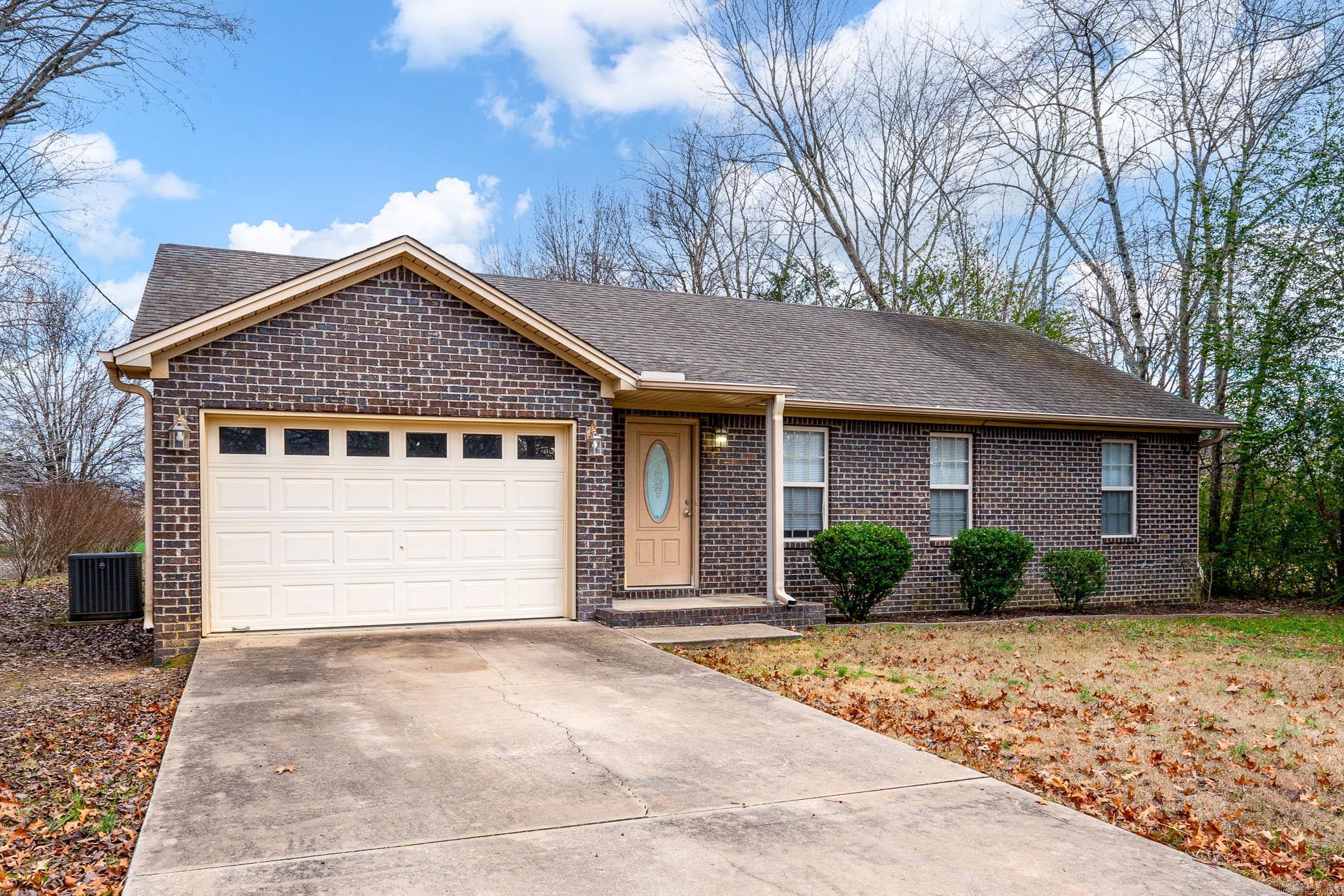 This cozy brick home features a two-car garage, a spacious driveway, and a neatly maintained yard. Inside, enjoy an open living space with vaulted ceilings, hardwood floors, and plenty of natural light. Located in a quiet neighborhood near schools, shopping, and dining, this home is perfect for you! Schedule your showing today!