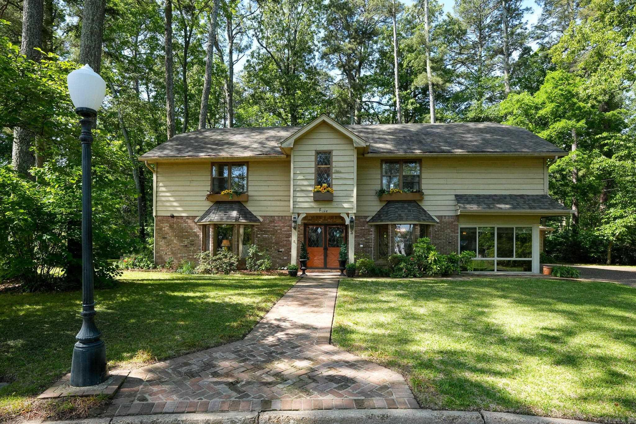 Welcome to this beautifully maintained English Tudor home, owned by the same family since 1971. Nestled in a private cul-de-sac, itās within walking distance of Jefferson Regional Hospital and Pine Bluff Country Club. Elegant leaded glass windows and flower boxes boost its curb appeal, while mature trees and landscaping create a warm welcome. Enjoy the spacious deck and covered patioāideal for relaxing or entertaining. Inside, youāll find 4 large bedrooms, 4 baths, formal living and dining rooms, and a cozy den with a wood-burning fireplace and solid wood paneling. The upstairs laundry adds convenience near all bedrooms. The updated kitchen (2019) features ample cabinets, island seating, and a hidden serving cart, flowing into a breakfast room with built-in desk and a sunroom perfect for morning coffee. Stone and hardwood floors add elegance throughout the main level. New roof (2018) and zoned CH/A systems (upstairs 2022, downstairs 2010). This must-see home is ready for its next chapter.