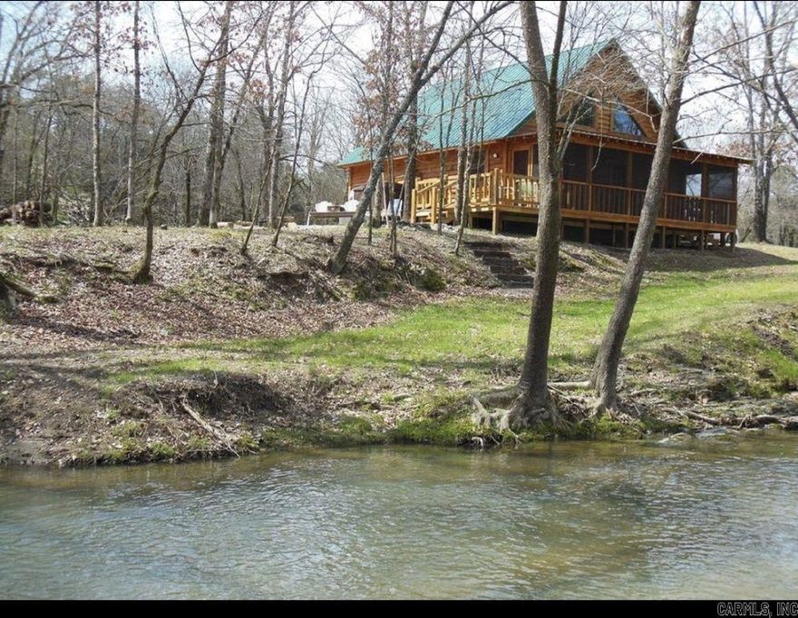 Charming log cabin nestled along the banks of Lick Creek in Norman, Arkansas. Currently operating as a successful vacation rental, with profit and loss statements available upon an accepted offer. In addition to the cabin, the property includes extra creekside land featuring RV hookups—perfect for expanding rental income or hosting guests. The cabin offers a warm and inviting layout with two bedrooms on the main level and a spacious loft upstairs. It is being sold fully furnished, making it truly turnkey. Enjoy peaceful creek views from the screened-in porch, which opens to a back deck with a seating area and hot tub. Beyond the deck, a fire pit and outdoor seating create the ideal setting for relaxing evenings by the water. Recent owner improvements include a new HVAC system, tankless water heater, refrigerator, fireplace insert, hot tub cover and heater, washer and dryer, and new water lines to exterior spigots. This unique creekside retreat combines rustic charm with modern upgrades and income-producing potential.