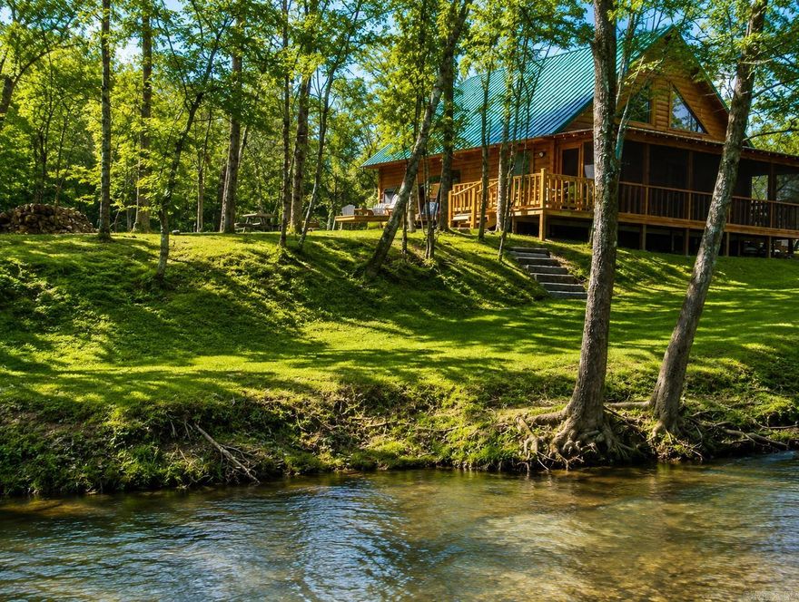 Charming log cabin nestled along the banks of Lick Creek in Norman, Arkansas. Currently operating as a successful vacation rental, with profit and loss statements available upon an accepted offer. In addition to the cabin, the property includes extra creekside land featuring RV hookups—perfect for expanding rental income or hosting guests. The cabin offers a warm and inviting layout with two bedrooms on the main level and a spacious loft upstairs. It is being sold fully furnished, making it truly turnkey. Enjoy peaceful creek views from the screened-in porch, which opens to a back deck with a seating area and hot tub. Beyond the deck, a fire pit and outdoor seating create the ideal setting for relaxing evenings by the water. Recent owner improvements include a new HVAC system, tankless water heater, refrigerator, fireplace insert, hot tub cover and heater, washer and dryer, and new water lines to exterior spigots. This unique creekside retreat combines rustic charm with modern upgrades and income-producing potential.