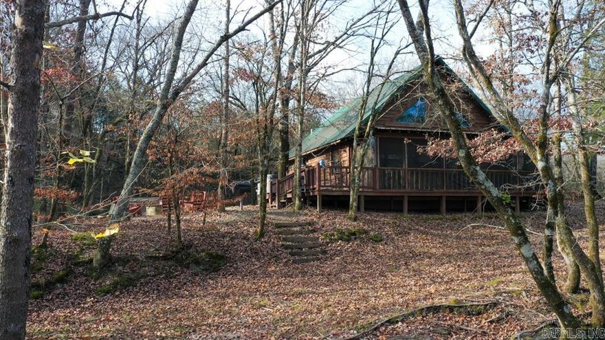 Charming log cabin nestled along the banks of Lick Creek in Norman, Arkansas. Currently operating as a successful vacation rental, with profit and loss statements available upon an accepted offer. In addition to the cabin, the property includes extra creekside land featuring RV hookups—perfect for expanding rental income or hosting guests. The cabin offers a warm and inviting layout with two bedrooms on the main level and a spacious loft upstairs. It is being sold fully furnished, making it truly turnkey. Enjoy peaceful creek views from the screened-in porch, which opens to a back deck with a seating area and hot tub. Beyond the deck, a fire pit and outdoor seating create the ideal setting for relaxing evenings by the water. Recent owner improvements include a new HVAC system, tankless water heater, refrigerator, fireplace insert, hot tub cover and heater, washer and dryer, and new water lines to exterior spigots. This unique creekside retreat combines rustic charm with modern upgrades and income-producing potential.