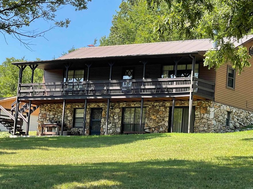 Ozark hidden Gem - This Beautiful wooded property sets high on an ozark hill and is nestled at the end of a long winding drive thru the forrest. The setting is picturesque with large white oak, pecan, redbud, dogwood and crepe myrtles sprinkled around the home place providing a breathtaking landscape for viewing off of the front porch. The drive reaches around the property for a circle drive passing thru a large carport. Large workshop approximately 24' X 40' with Power, accessorized with an abundance of shelving, work benches etc and divided into 2 separate rooms with back room have window unit AC. Built in Vault safe for anything that needs to be securely stored. The main level of the home has gorgeous Hickory hard wood floors throughout most and consists of Kitchen, dining, living room, 2 bedrooms and 1 and 1/2 baths, stairs off of dining area provide access to the full walkout basement that has a multi purpose room currently used as game room, laundry room with Sink, closet with well pump pressure tank and service entrance for power. full bathroom, bedroom and additional large storage room with shelving. You enjoy the manicured grounds through the many windows and sliding doors