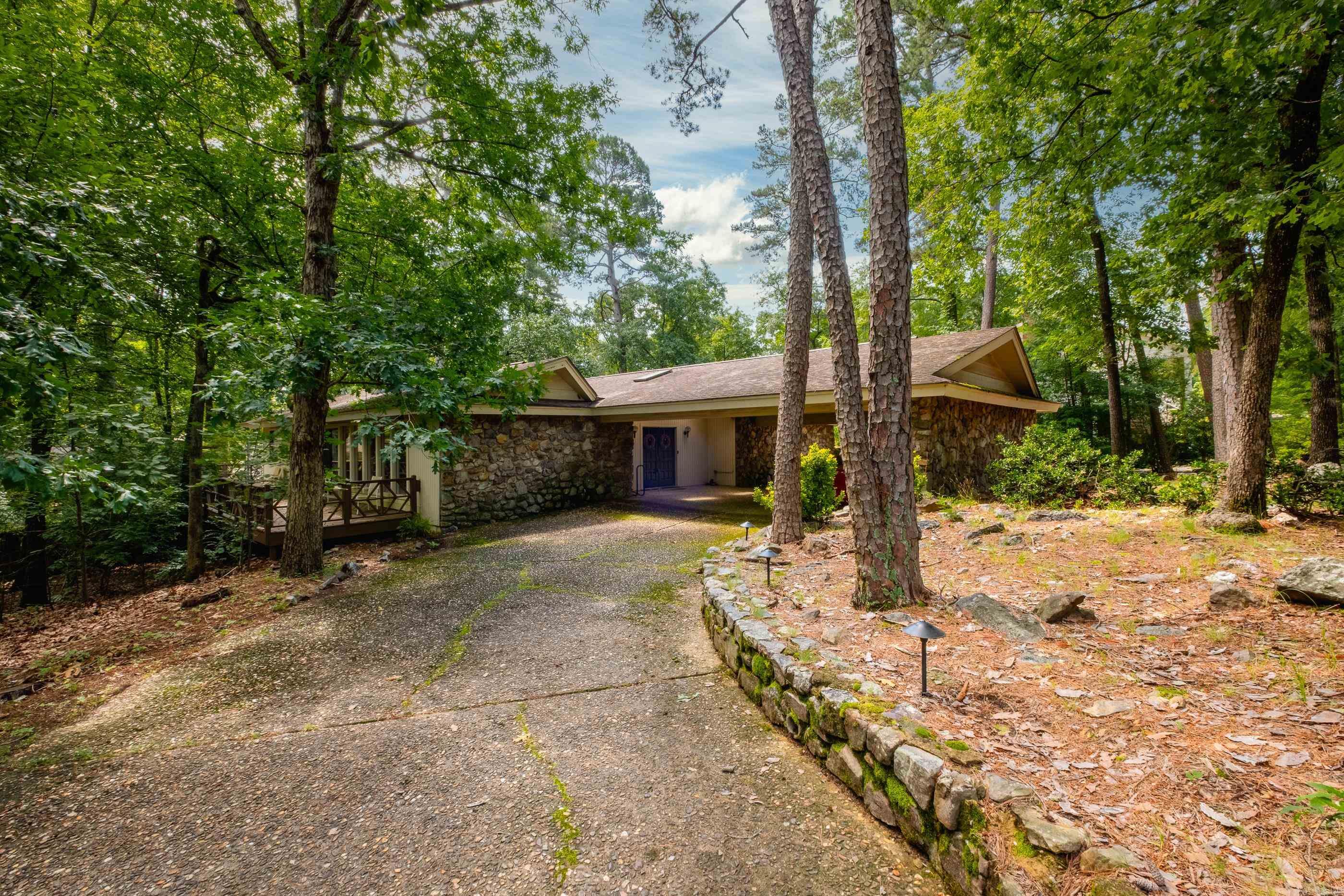 Located on a private cul-de-sac, this distinctive home sits on a large lot beneath a canopy of mature trees, offering both privacy and charm. Vaulted ceilings and skylights throughout fill the interior with natural light and a spacious feel. At the center of the home, a glassed-in, tiled atrium creates a serene space, ideal as a sunroom, office, or garden retreat. Formal living and dining areas are anchored by an impressive dual-sided rock wood-burning fireplace. The lovely kitchen features quartz countertops, a gas range, ample counter space, and opens to a den with glass doors leading to a wraparound deck along the side and back of the home. The primary suite includes vaulted ceilings, a large bath with soaking tub, and access to its own private deck and patio. Two additional bedrooms share a full hall bath, with an extra half bath nearby. A separate laundry closet adds convenience. The homeās overall character blends soft contemporary and traditional elements with warmth and originality. New roof July 2025. Come see!