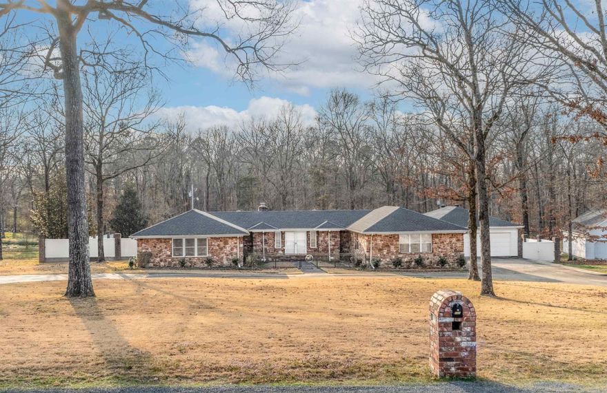 One-level traditional home in Quail Creek Estates, just minutes from the Maumelle backside off Hwy 365 (MacArthur corridor), situated on 1.76 level acres. This 4-bedroom home offers 2 full baths and 2 half baths, plus an additional half bath at the pool gazebo and another half bath in the heated shop. Features include a 4-car garage, wood and tile flooring throughout (no carpet), granite countertops, copper sink, central vac, fiber optic internet, and 4 surveillance cameras. The backyard is fenced with extensive composite fencing and brick columns, fully enclosed and accented with LED lighting. Outdoor amenities include an 18x36 in-ground pool, hot tub (motherboard replaced 2022, new cover), covered patio, and pool gazebo. Heated shop includes electricity and half bath. Updates include new ceiling fans (2023), chair-height commodes (2023), remodeled hall half bath (2023), primary bedroom flooring (2022), primary bath linen cabinet (2023), septic pumped (2022), LED fence lighting (2023), and pool jets sealed (2023). Pool ecosystem system with copper plates available. (Pool light inoperable) Exterior Iron front gate installed 2025. New Roof - 2026