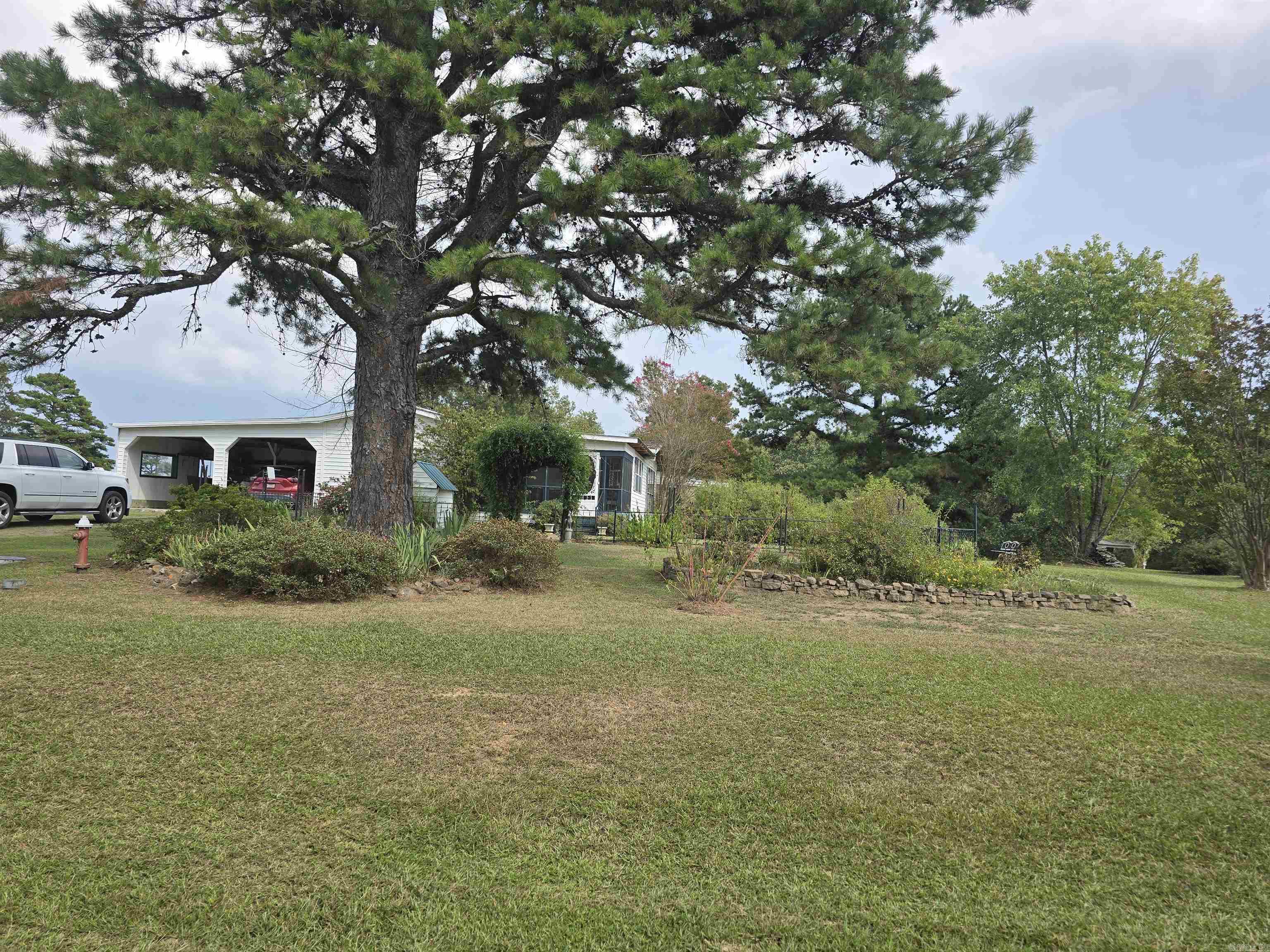 This absolutely stunning 10-acre property is a must see. This 1100 sq ft mobile home is on a permeant foundation and has been added on to, to increase the square footage to 1866 sg ft! Additions include a 3rd bedroom, huge dining area, laundry room and entry way. Other additions not included in the square footage are an office area, sunroom and enclosed porch. It also has a screened in front porch and 2 car carport. This home sits on the most beautiful piece of property! 5 acres are gorgeously landscaped to include several types of blooming trees and flowers, blueberry bushes, grape vines, pear, cherry and fig trees, muscadine vines and asparagus that comes back every year! The 5 wooded acres provides a perfect place for the hunting enthusiast or nature lover. It has a creek that runs through it attracting all kinds of wildlife. The roof of the home was resealed in April of this year, and the water heater and heat & air system are approx. 3 years old. This home has so much more to offer, make your appointment today to see this stunning property!