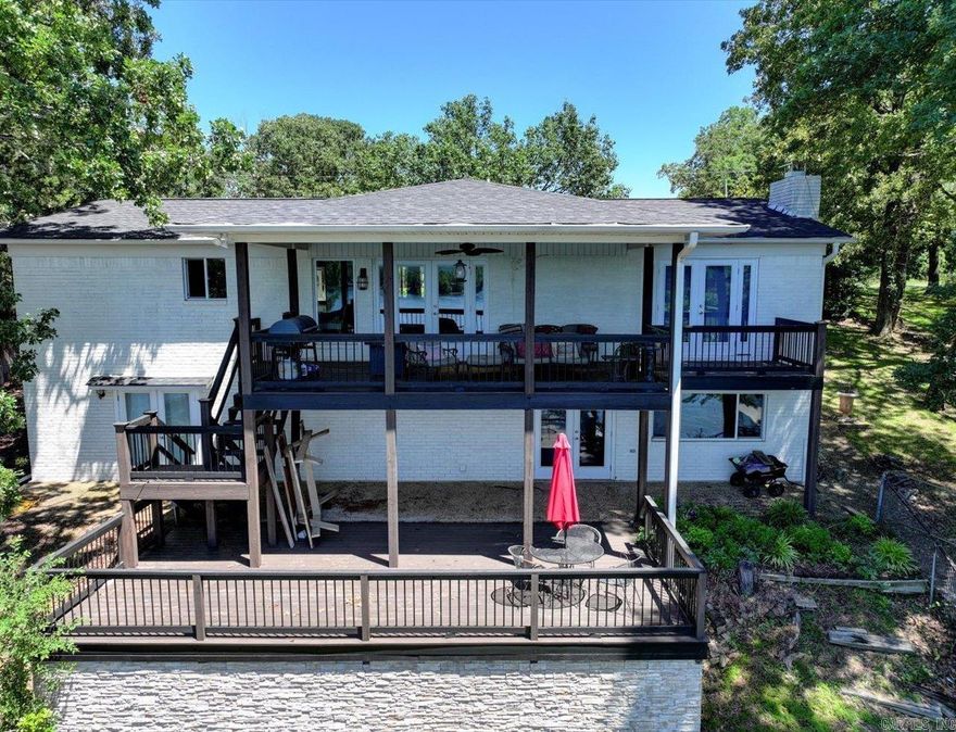 Charming 3 bedroom / 2.5 bathroom home with 112 ft of shoreline on Lake Hamilton. This house is more like the size of a large condo with your own yard, outdoor decks and 2 stall boat dock but with no POA dues. Enjoy the privacy of your own entrance and outdoor space. The two decks offer a lot of options for outdoor living/entertainment areas. This home had a nice update in 2022.There are upper and lower living areas both with bedrooms and ensuite bathrooms.  The little bedroom downstairs is more like a bunk/bonus room.  It currently serves as a bunk room for the grandkids.  Also, upper and lower washer and dryer utility rooms. The kitchen, living, dining area lake views are mesmerizing. Look straight out across Lake Hamilton to Mt. Riante vista views. Easy living in this lake home for sure. New roof in 2024, new HWH and HVAC within last few years.