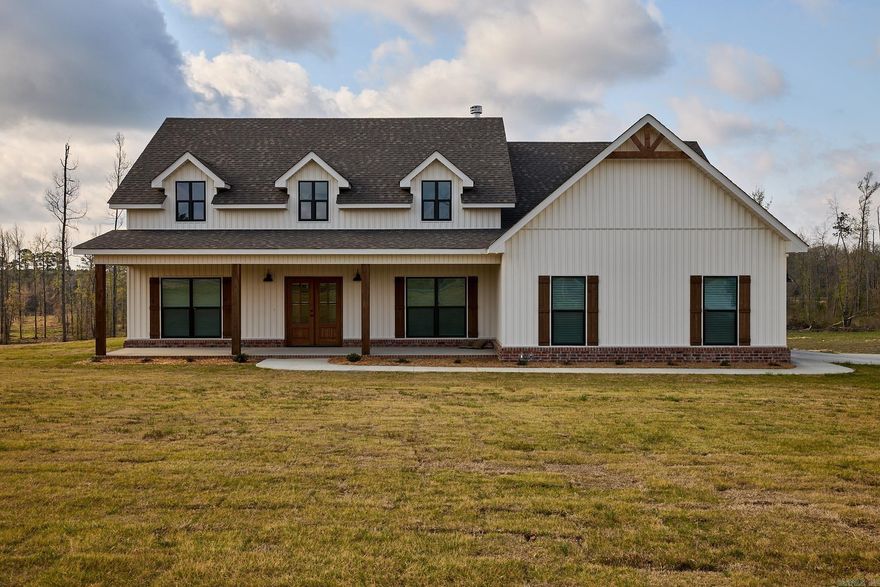 New construction in a growing area of Bauxite featuring 3 bedrooms, 2 bathrooms, and 2,217 sq ft. You’re greeted by a large front porch with double front doors and a side-load garage. This open-concept home offers a vaulted, beamed living room ceiling with a woodburning fireplace, hardwood floors in the main living area, carpeted bedrooms, and tile in wet areas. The kitchen includes quartz countertops and a walk-in pantry. Just off the foyer is a versatile office or dining room with a closet. The primary suite features a soaking tub, walk-in shower, double vanity, and private water closet. Additional highlights include a mudroom, a separate laundry room with sink and folding area, and a spacious backyard.