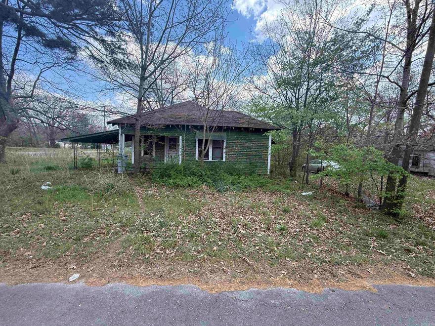 The lot has beautiful large trees, water meter, hook ups for Trailer, storm shelter, building and a old house that might be repaired or removed.