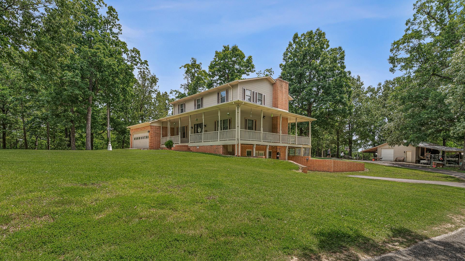 Set on 3 serene acres with mature trees, this spacious three-level home offers room to spread out and features a 24x24 shop sheds on both sides, wraparound deck, and walk-out basement. Inside, the main level boasts an updated kitchen with gas range, microdrawer, serving-height bar, and a built-in wet bar in the dining area. A cozy gas-log fireplace warms the living room with additional sitting area. The oversized laundry room includes a full bath for added convenience. Upstairs you’ll find three bedrooms and two baths, including a generous primary suite with double vanities and a tiled walk-in shower with seat. The basement offers incredible flexibility with a full second kitchen, game room, 4th bedroom, hobby room, and a full bath—perfect for guests or multi-generational living. Double garage, privacy, and functionality all in one, come see the updates!