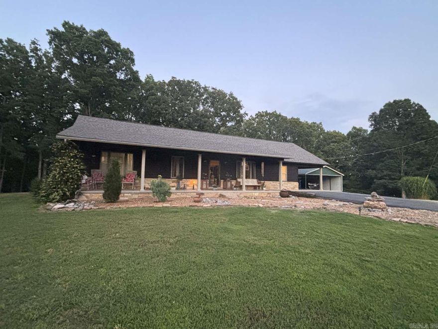 Beautiful, 3 BR/2BA rock and cedar siding home on 10.4 acres m/l. Including acreage across the highway from home. The home includes an asphalt driveway with turn around and an RV hook-up. This 1,526 sq. Ft. Custom built, rustic style home is surrounded by beautiful mature trees and low maintenance rock landscaping, porches across the front and back of the home and a 3 car carport. In the back is a multi level deck with plenty of room for entertaining, brick/stucco pizza oven, and fire pit area. Three acres of the property is fenced with a gate at the highway and an additional gate in the back. The home features an open floor plan with vaulted ceiling, wood flooring, and attractive rock gas fireplace. The kitchen has granite countertops, a large granite island, modern soft close cabinets, open shelving, and newer kitchen appliances. The master bedroom has an oversized walk-in closet and adjoining bath with a claw foot tub. The property includes a Yoder built cedar green house, fruit trees, a house to raise chickens, a barn with a wood floor and lean-to, a newer 30x30 shop with a 10 foot lean-to, electric, wood stove. Updates to property: HVAC, roof, well pump.