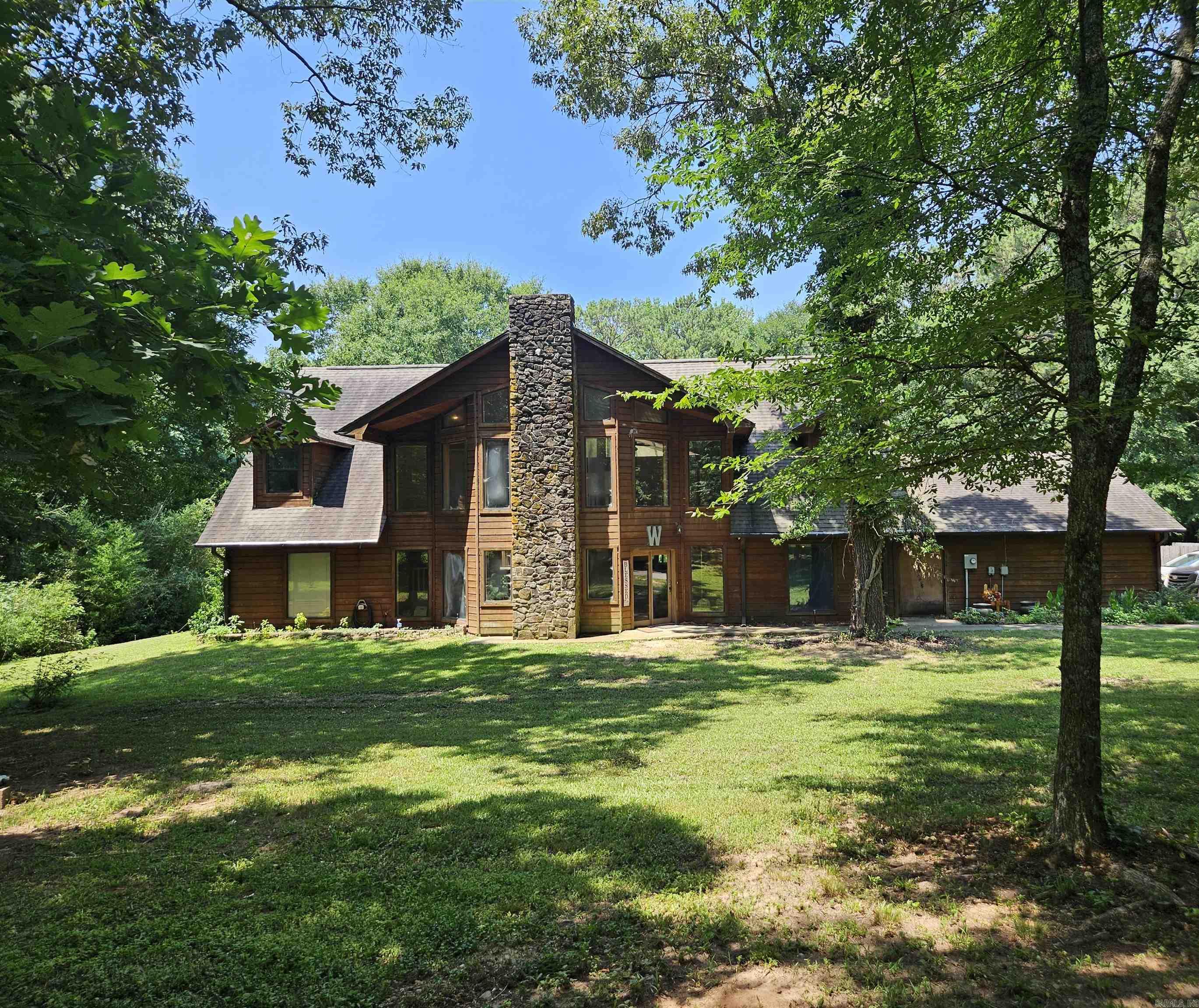 Tucked away in a serene setting, this spacious 4BR/4BA home features an open dining and living area with vaulted ceilings, a striking rock fireplace, and a wet bar. The gourmet kitchen is equipped with granite countertops, a gas stove, wall oven, island bar, and dining area with French doors leading to the deck. This is home is perfect for entertaining and enjoying poolside views. Upstairs offers 2BR/2BA, each with walk-in closets and built-in desk space. Additional upstairs living space provides room for entertaining, along with French doors opening to the upper deck. The downstairs primary suite boasts a walk-in-closet, oversized tub, and tiled shower. The Large laundry room downstairs with a wash sink is another plus feature of this home. Don't miss the private saltwater pool that completes this beautiful home.