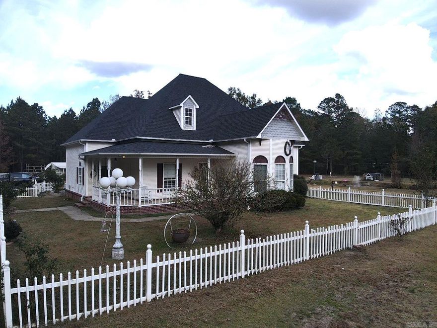 This one-of-a-kind property is nestled on 7.01 fenced acres.  It is close to town but far enough out to get all the benefits of living in the country.  2121 sq ft, 3/2 bath with an additional bonus room upstairs.  Beautiful landscaping with a bridge lead to a fully stocked pond, bountiful flowers and bushes are everywhere on this very peaceful setting.  Other buildings include a shop/apartment ready to be completed and utility storage building.  There is an above ground swimming pool, white picket fence, outside pole lantern are just a few of the amenities on the property.  Price to sell, this one will not last long. Call or text today to schedule a showing.