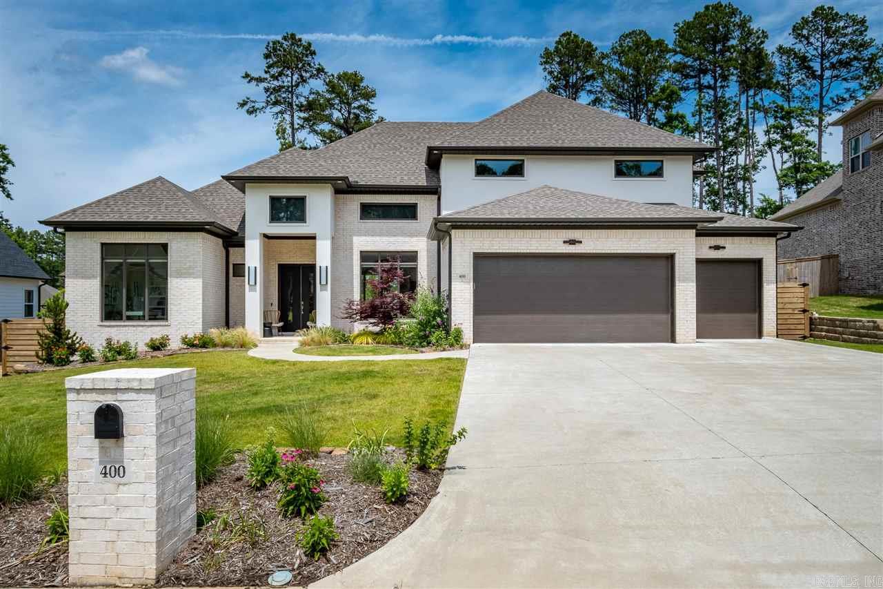 Exquisite 2019 home in coveted Chenal's Ensbury Neighborhood. Seller added equipped theater room (w/wet bar), covered outdoor kitchen (limestone counter/mini-frig/SS sink/firewood storage for your fire pit), hardwood-stamped concrete patios, extensive landscaping & upgraded iron/wood fence. Step into a gorgeous open foyer/family rm/dining rm/kitchen & see the covered patio. 4 bedrm suites (2 up/2 down). Office. Laundry rm. Fabulous quartz counters & hardwoods. Amenities+ not listed. YOUR NEW STUNNING HOME!