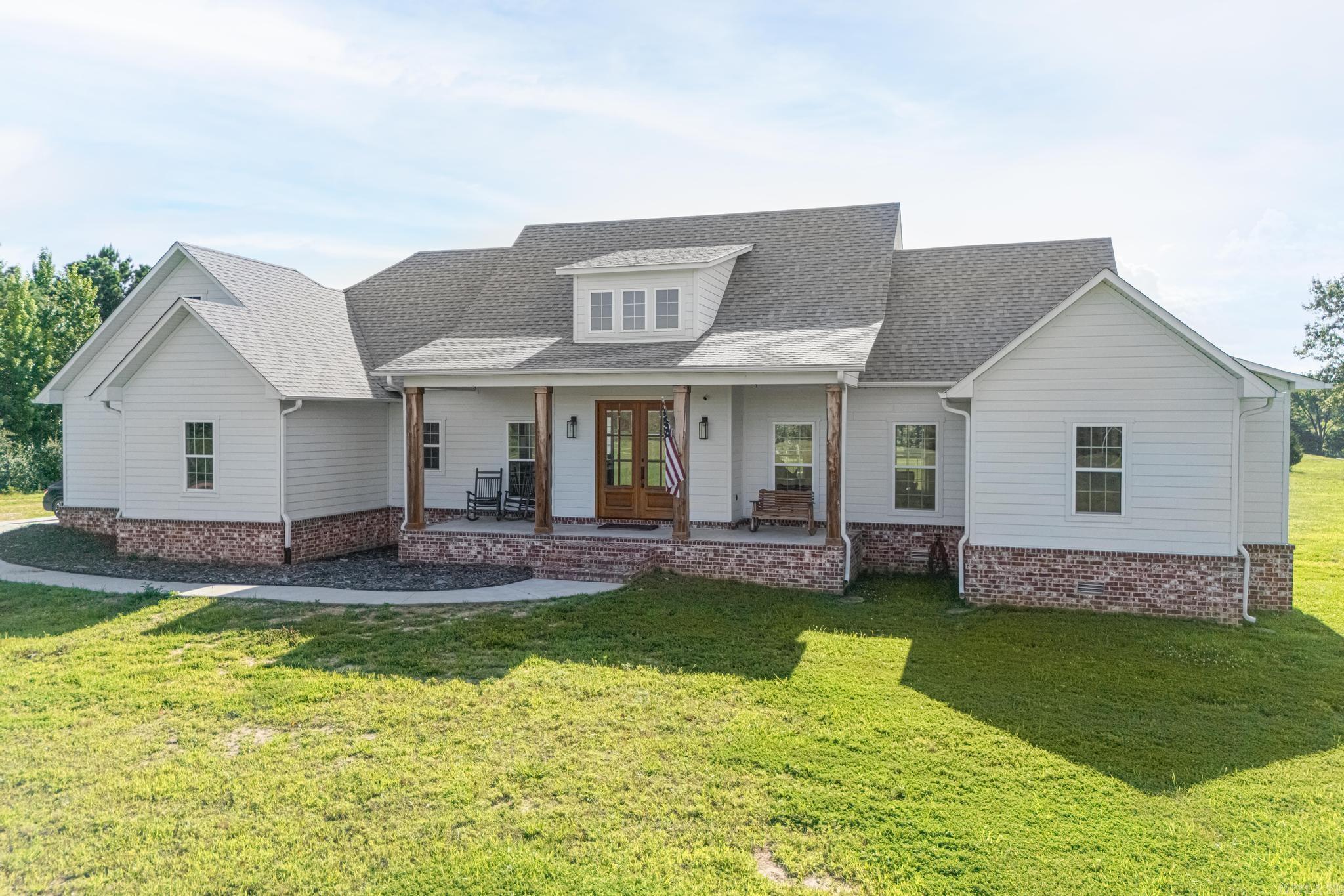 Gorgeous Farmhouse style home that's "Priced at Recent Appraisal". This home totally encompasses this style from the white walls ... hardwood floors ... brick and tile floors ... lighting style ... fixture style ... kitchen cabinet style with quartz countertops and awesome walk-in pantry ... and shiplap touches everywhere! Interior features an open concept and split bedroom design, volume ceiling in living/dining area and fireplace, surround sound and amazing primary bedroom with spectacular ensuite bath. Exterior features include 40+ acres with stocked pond ... covered back porch ... Hardie Board siding ... concrete sidewalk and pad for firepit ... storm shelter in garage floor ... gas hookup on back porch for grill PLUS a 40x40 insulated shop with electric, overhead door and side door, windows and 12 ft ceiling with plumbing roughed in and shop even has its own septic tank! Livestock of all sorts IS allowed on this property so if its country life you crave ... this is your house! NOTE: This property is only a 10-minute drive from Glen Sain Ford and is in Paragould School District ... just has a Marmaduke address. SEE AGENT REMARKS!