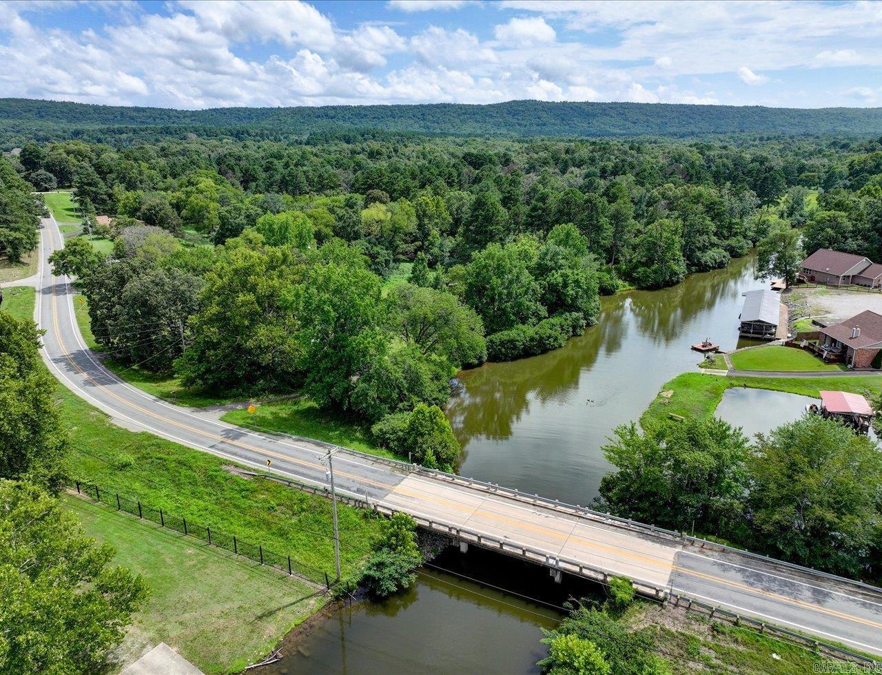 ATTENTION DEVELOPERS - RARE LAKEFRONT OPPORTUNITY! This is one of the last big parcels of land on Lake Hamilton for development. +/-7.76 acres with +/- 1573 feet (est.) of lake frontage in the highly sought after HWY 7 South corridor, with over 350 feet of frontage on HWY 290. This prime property is located in Lakeside School District and all utilities are at the highway. Land is flat with two beautiful inlets surrounded by mature oak and pine trees—creating a serene and picturesque setting for your next development. This is the best parcel of lakefront property in a while. Whether you're envisioning lakefront homes, a resort-style community, or a private retreat, the possibilities are endless. Opportunities like this don’t come around often—schedule a visit and see for yourself why this is one of the best parcels to hit the market in years! There is a mobile home and outbuilding on the property, but the value is in the land and there is one sewer pump for the mobile home.