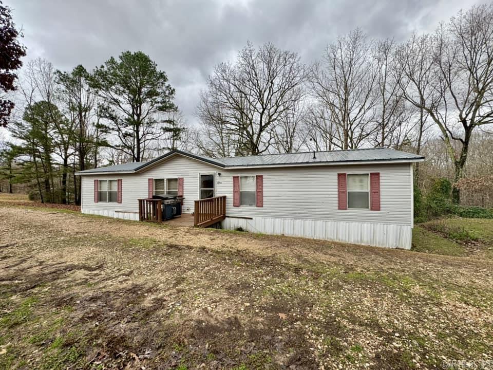 Three-bedroom, two-bath double wide manufactured home offers a spacious 1,440 square feet of comfortable living space, situated on a generous 5.4-acre. The exterior features a welcoming deck and porch, perfect for enjoying the serene surroundings and views of the natural landscape. Inside, the layout is designed for both functionality and comfort. The open-concept living area seamlessly connects the living room, dining space, and kitchen, making it ideal for family gatherings and entertaining guests. The kitchen is equipped with modern appliances and ample counter space, perfect for cooking and meal prep as well as a new dishwasher in the box ready to install. The master suite includes an en-suite bathroom for added privacy, while the additional bedrooms share a well-appointed second bathroom. Outside, the property is a true haven for hobbyists and those who enjoy rural living. A sizable shop provides plenty of space for projects, storage, or even a workspace. The chicken house is perfect for those interested in raising chickens for fresh eggs or simply enjoying the beauty of nature. This all-electric home combines modern conveniences with the tranquility of country living.