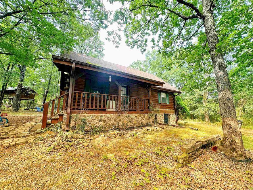 Nothing gives that cozy, peaceful vibe quite like a cabin surrounded by trees does- & there is a bonus with this one... it is near Greers Ferry Lake!  Step inside and take it all in... the gorgeous lofted ceiling with beautiful beams & stone fireplace make this one a decorators delight! You have options in the 3 level layout- use the downstairs as a main suite with a bedroom, bathroom (w/ a CLAW FOOT tub) & living area OR let it serve as 2 bedrooms! On the main level you will find the living room, updated kitchen, bedroom & bathroom complete with antique porcelain sink & beautifully tiled shower!  Upstairs, you'll find the loft, giving you a bird's eye view of this cabins charm! The back deck is ready for you to  relax on & the tree house is ready to be filled with laughter and play!