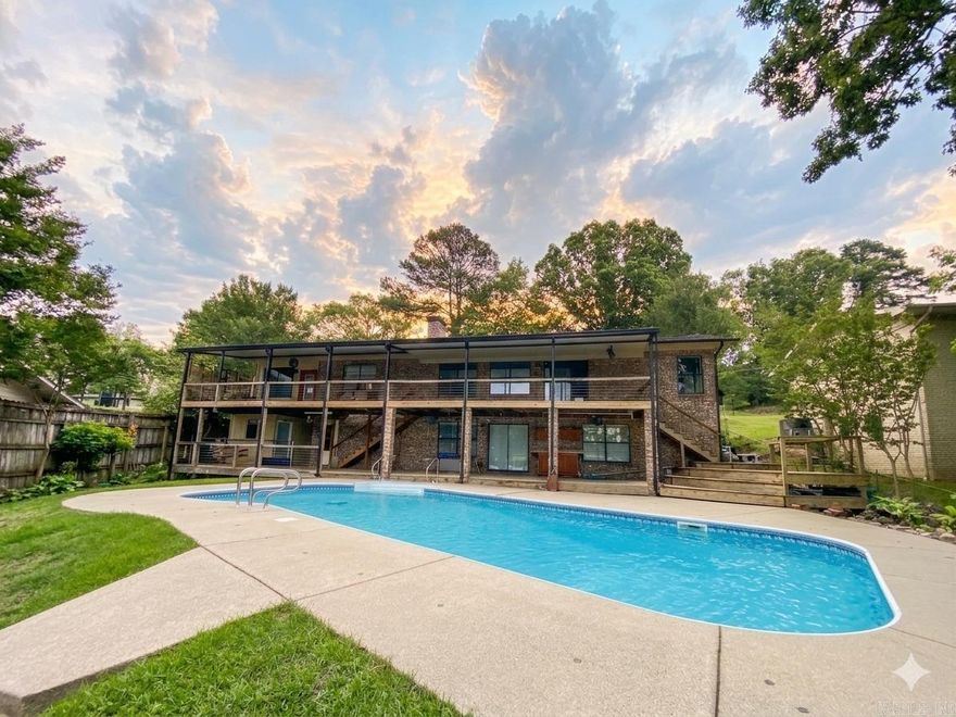 Experience the ultimate Lake Hamilton lifestyle in this stunning two-story waterfront retreat, perfectly designed for entertaining. The main level features an open living room with a fireplace, a large primary suite with a 2021 updated bath, and a second bedroom and bath. A private sunken sunroom at the far end of the home offers the perfect quiet space for a hobby room or office. Most rooms walk out to an expansive, full-length deck overlooking the heated salt-water pool.  The walk-out lower level adds a third bedroom and bath, a second living area, a workshop, and a massive storage room spanning the home's full length. Step out to the lower patio and fenced yard, just a few steps from your double-stall covered boat dock. Recent updates offer total peace of mind: new roof, gutters, and dock roof (2024); new LVP, carpet, hardwood, and pool safety cover (2025); and fresh paint, trim, and lighting throughout. Conveniently located by car or boat, this move-in-ready gem is close to everything Hot Springs has to offer. Enjoy resort-style living with a 2022 pool heater and updated sprinkler system (2025). Your lakefront oasis awaits!