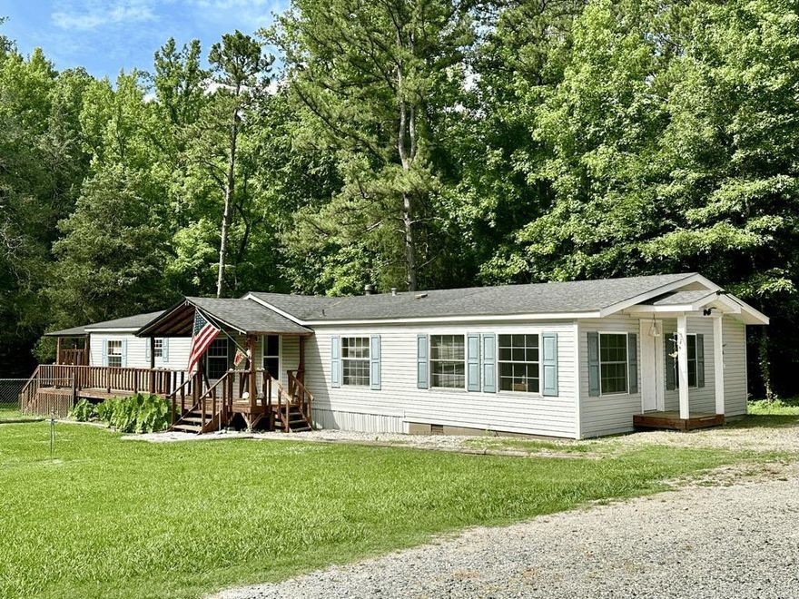 2.15 acres of unrestricted land within minutes of Lake Ouachita.  Built in 1998 this doublewide home has 2016 sq ft living space with 3 bedrooms, 2 baths, and a bonus room 25x16) that could be a bedroom, game room, sewing room, or a guest suite. Covered front porch, 12x25 covered deck that overlooks a creek. Chainlink fence connecting to the back deck gives your furry friends or babies room to roam. Workshop/storage for your toys. There is an old well, but not in use. Home is on city water, there is a septic. Great for the people looking for a lake home. Call for an appointment. Appliances convey. CHA and wood burning fireplace.