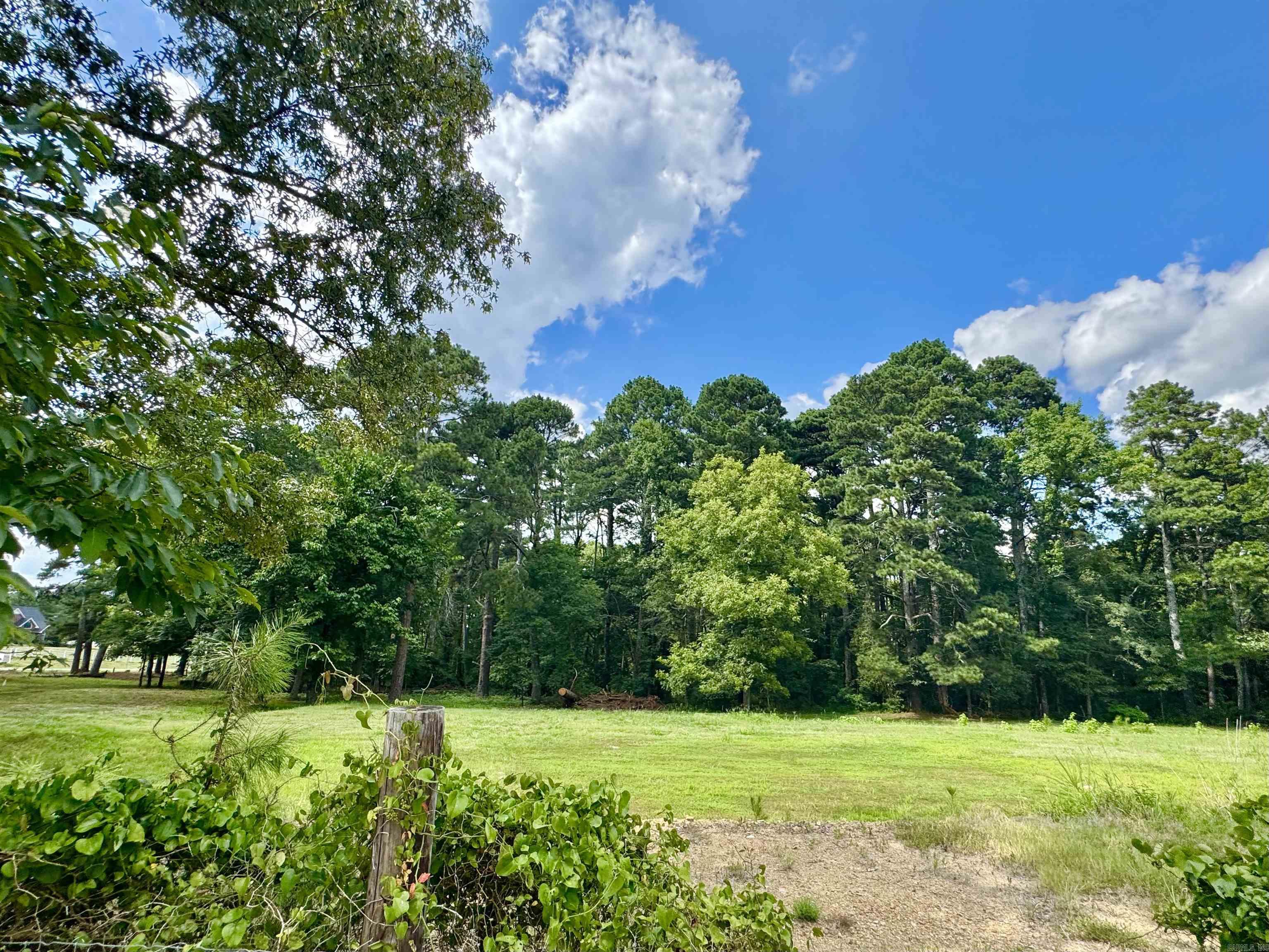 Location! Location! Location!! Beautiful land!! Right on the cuff of Sunshine Rd!!! Great Potential!!! Grand opportunities!!! This property has so much to offer! Being walking distance to Lake Hamilton School and right behind the Circle K!!! You could build a business there and have fantastic visibility without spending a million dollars on the main highway. This sets back off the highway with Lots of visibility. Close to the new Dollar store and Health club!! You could build your dream home and have lots of Access to all areas of your property!!There is a huge building pad already in place to build a huge shop or metal building!! All ready to pour you slab and start the process!!The old home place is so precious built in 1940 with lots of memories and beautiful wood interior. The seller does not want the house dozed off, If someone does not want the home he will move off the property. There is also a wet weather small creek on the property. There is city water, you will need to get a septic to build, Buyers responsibility to get commercially zoned. Make your offer today not many tracts like this available!!!