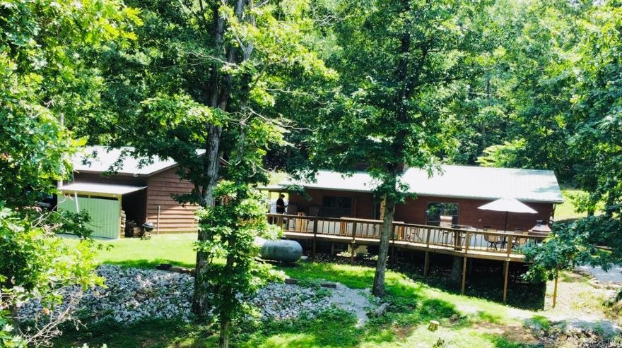 Beautiful custom-built cabin on 13.5 private acres MOL located near the music, eateries, & shops in Mountain View & quaint Leslie, & in close proximity to Little Red River, Blanchard Springs, & Buffalo Natl River featuring a warm all-wood interior, large windows for natural light & breathtaking mountain & woodland views, efficient mini splits, plus a woodburning stove with glass doors in the open living/dining area for cool Fall nights and snowy Winter days. The spacious primary bedroom has a cedar lined walk-in closet with a large safe for storing valuables plus an ensuite bathroom that doubles as a safe room with a walk-in shower & lighted vanity mirror. Two additional bedrooms; one upstairs with large closets, & one off the living room, perfect for use as a home office. The unique main bathroom has a red soaking tub with shower, vaulted ceiling, & large vanity with mirror. The efficient galley kitchen has a new stainless refrigerator, a gas range, & adjoins the oversized laundry/pantry room with utility sink & custom counters & shelving. Plus, there is a large wrap-around deck with spectacular sunset & wildlife views and a detached 30x40 2 car garage/shop. A dream property!