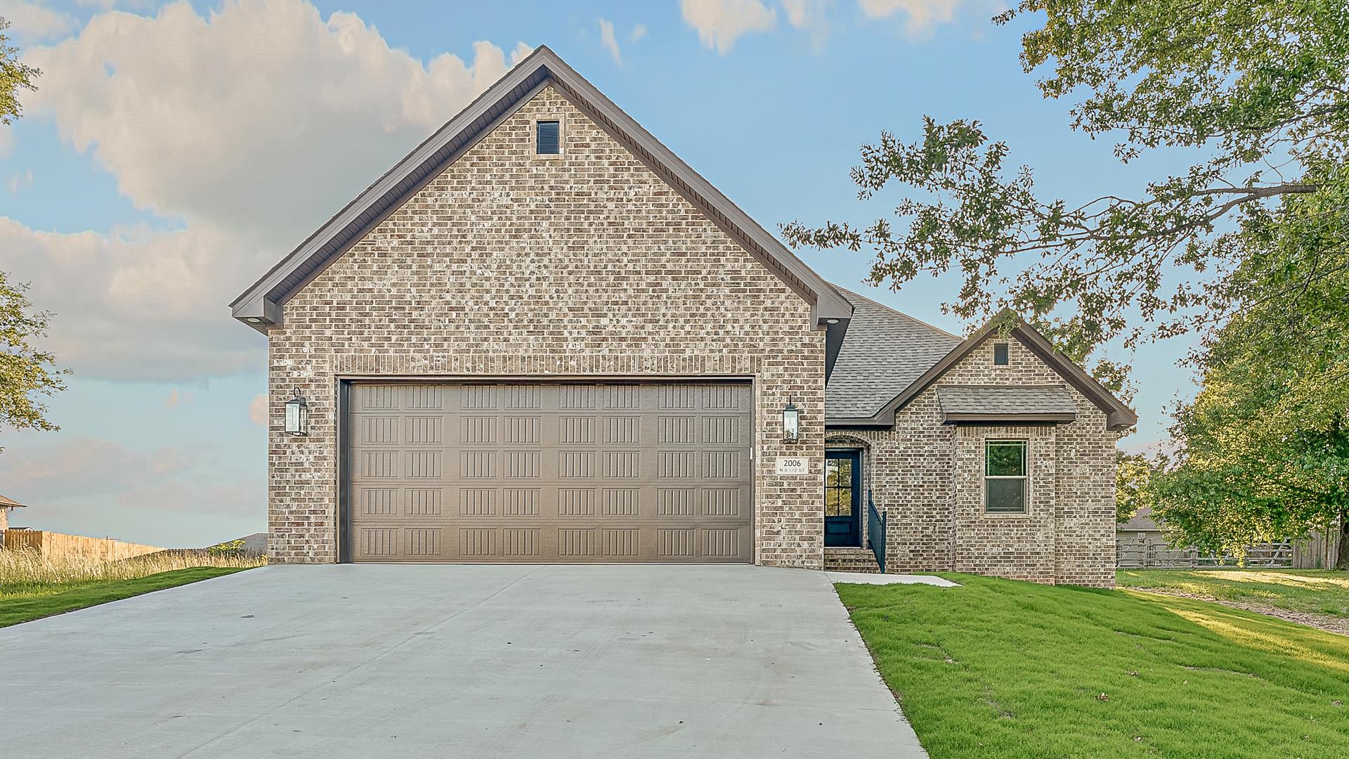 This all-brick, one-level new construction blends style and comfort with over 1,600 sq ft, 3 beds, 2 baths, and a 2-car garage. The great room features a modern electric horizontal fireplace, while the kitchen shines with custom glass pantry doors and an open layout built for hosting. The primary suite is a true retreat—featuring a custom tile shower, separate soaking tub, and leathered textured granite countertops that add a bold touch. Thoughtful extras include a custom glass laundry room door, a built-in hall tree with cubbies by the back door, and a covered patio perfect for relaxing. Situated on a shade-tree lot, this home delivers fresh design, functional space, and stylish finishes from front to back!