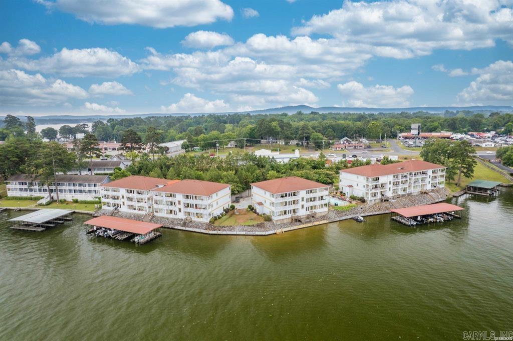 Nestled in the heart of Paradise Bay, this stunning lakeside condo is one of the largest in the area and offers unparalleled luxury and convenience. Positioned on a spacious wide cove adjacent to the main channel, the unit spans two levels, both accessible by an elevator, making every corner easily reachable. Originally designed as the developer's model unit, it boasts an expansive floorplan with thoughtful details throughout. The main level features a large primary suite with a private bath and walk-in closet, as well as a second bedroom or office with its own bath. Hardwood floors flow seamlessly throughout, complemented by elegant coffered 9-foot ceilings and crown molding. Enjoy cozy evenings by the rocked fireplace in the living room, or step onto the large covered balcony to soak in the breathtaking lake views. The kitchen shines with granite countertops, a breakfast bar, and all appliances includedācomplete with a built-in ice maker and a wet bar with sink and ice maker for entertaining ease. The lower level is a versatile space, perfect for a man-cave, mother-in-law quarters, or guest retreat. It includes a rocked fireplace, a second wet bar with a sink and refrigerator,
