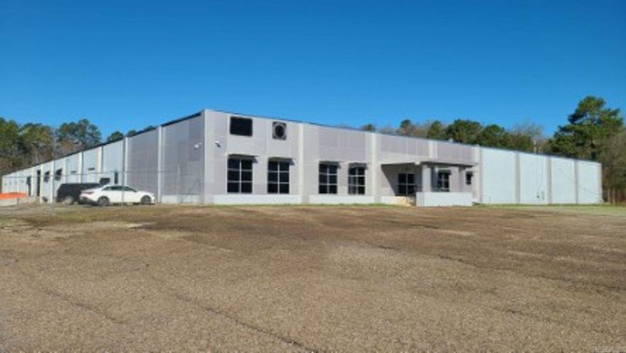 Setting on 13+ acres of land, this expansive 61,178 square-foot light industrial warehouse also offers 8,112 square-foot of office and showroom space. Zoned for light manufacturing, with 10+ loading docks and 2 large drive-in overhead doors for easy access. Highway frontage offers easy accessibility for logistics and business operations. All city utilities with a fully sprinkled dry fire suppressant system, Heavy electrical service, overhead heaters in warehouse/manufacturing area, 26ft open span and a large fenced in yard for truck access and parking. this solid cement building was built to last.