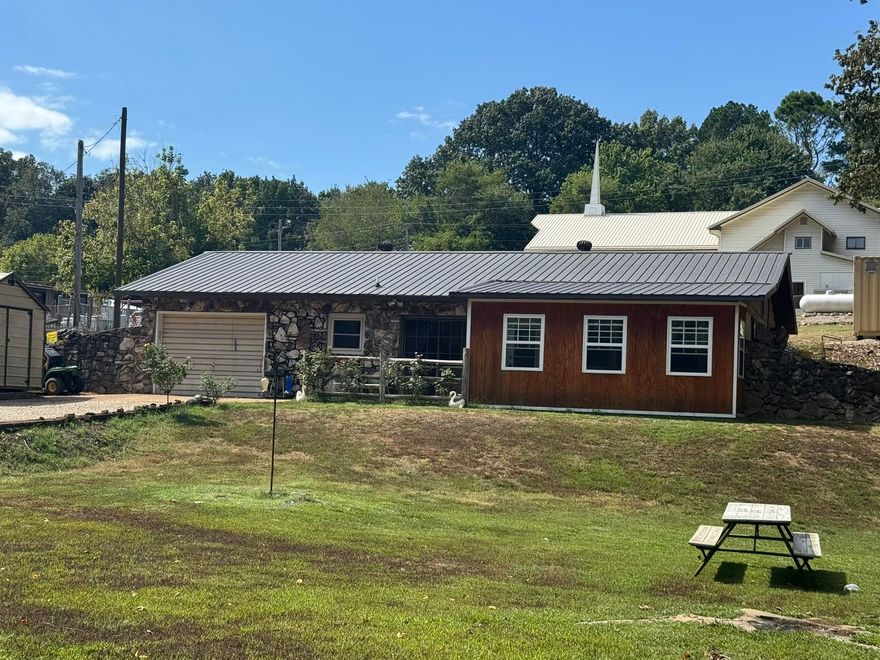 A charming stone earthen home in Hardy, Arkansas, featuring 2 bedrooms and 1 bath, all on a single level. This cozy, efficient home offers a metal roof, a garage, and a bright sunroom perfect for relaxing or enjoying the view. The spacious yard overlooks a peaceful creek, providing a serene outdoor retreat. Located a short distance from the Spring River, this low-maintenance home offers great value and is ideal as a nightly rental or a cozy primary residence.