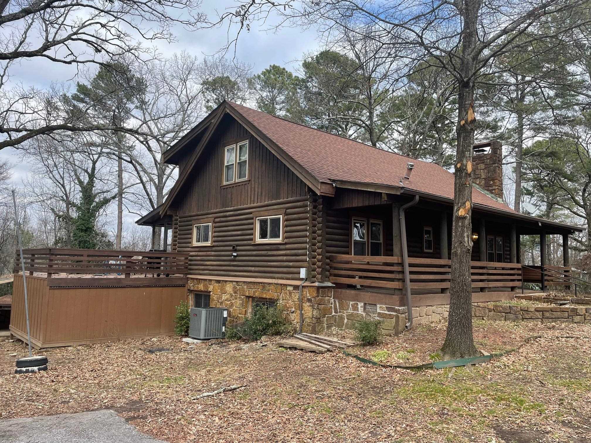 Discover your secluded sanctuary in the heart of Hot Springs, just 1/2 mile from Oaklawn Casino. This Furnished 2 Bedroom 2 Bath, 2000+ sq ft authentic log home is a blend of rustic charm and modern comforts. The vaulted ceilings adorned with exposed log beams welcome you, creating an inviting and spacious ambiance filled with an abundance of natural light. The heart of this home is the great room, anchored by a native stone fireplace, showcasing the knotty pine floors that run throughout. The kitchen boasts granite countertops, an under-mount sink, and stainless-steel appliances. One of the remarkable features of this property is the captivating outdoor space, which feels like a hidden oasis. It's a place where you can create lasting memories and enjoy the natural surroundings.