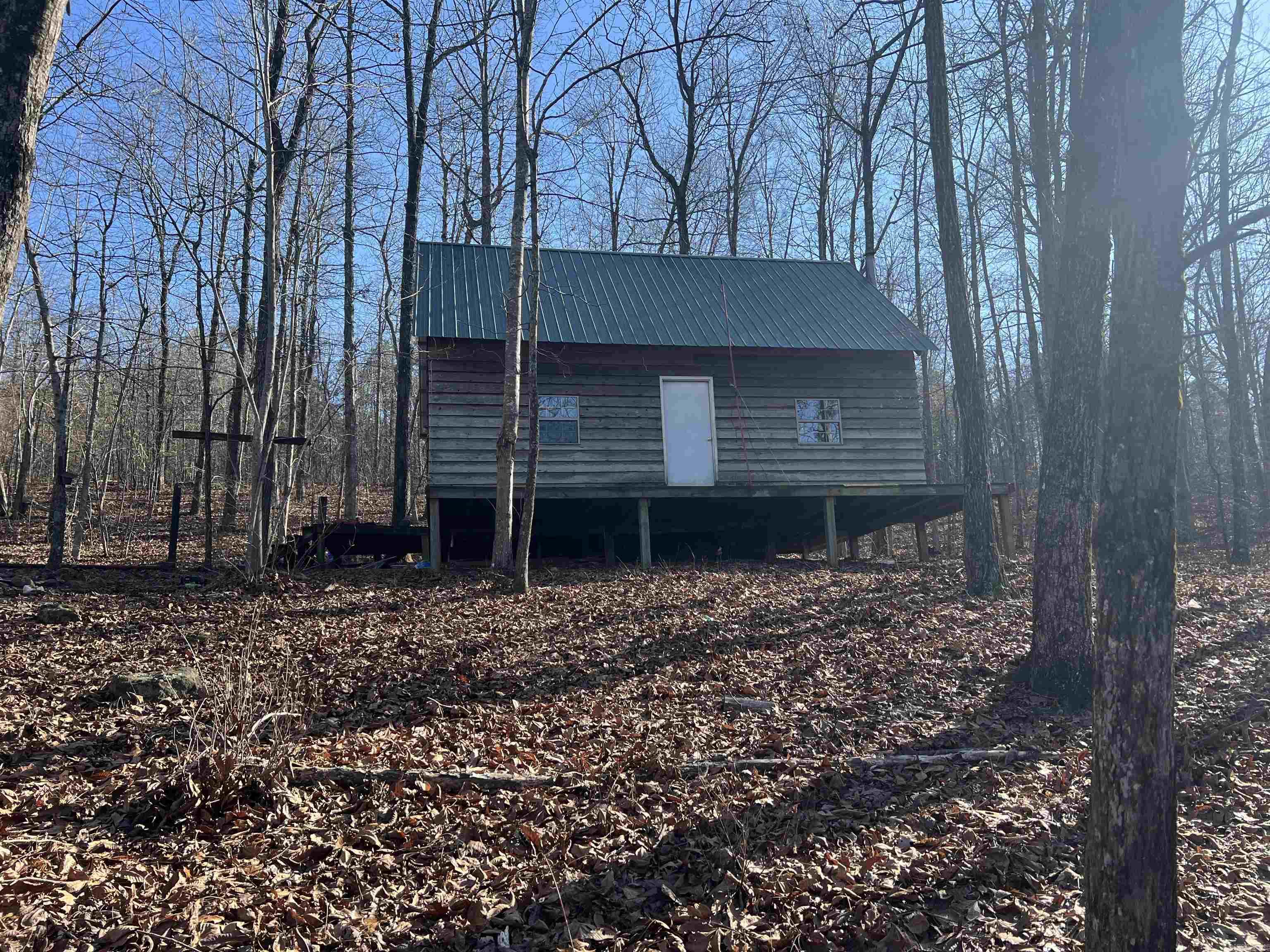 This 50-acres with a cabin features prime hunting land with a year-round creek, providing a consistent water source that attracts large populations of whitetail deer, bear and wild turkey. Whether you’re an avid hunter or just seeking a peaceful retreat in nature, this property provides a rare opportunity to own a slice of quiet wilderness. Numerous caves, waterfalls and natural wildlife trails are located throughout the property. The 900 sq foot cedar cabin has a wood burning stove, is wired for a generator & has a septic & water storage tank (used for plumbing). This property is perfect for a hunting camp, off grid living or weekend retreat. *See agent remarks