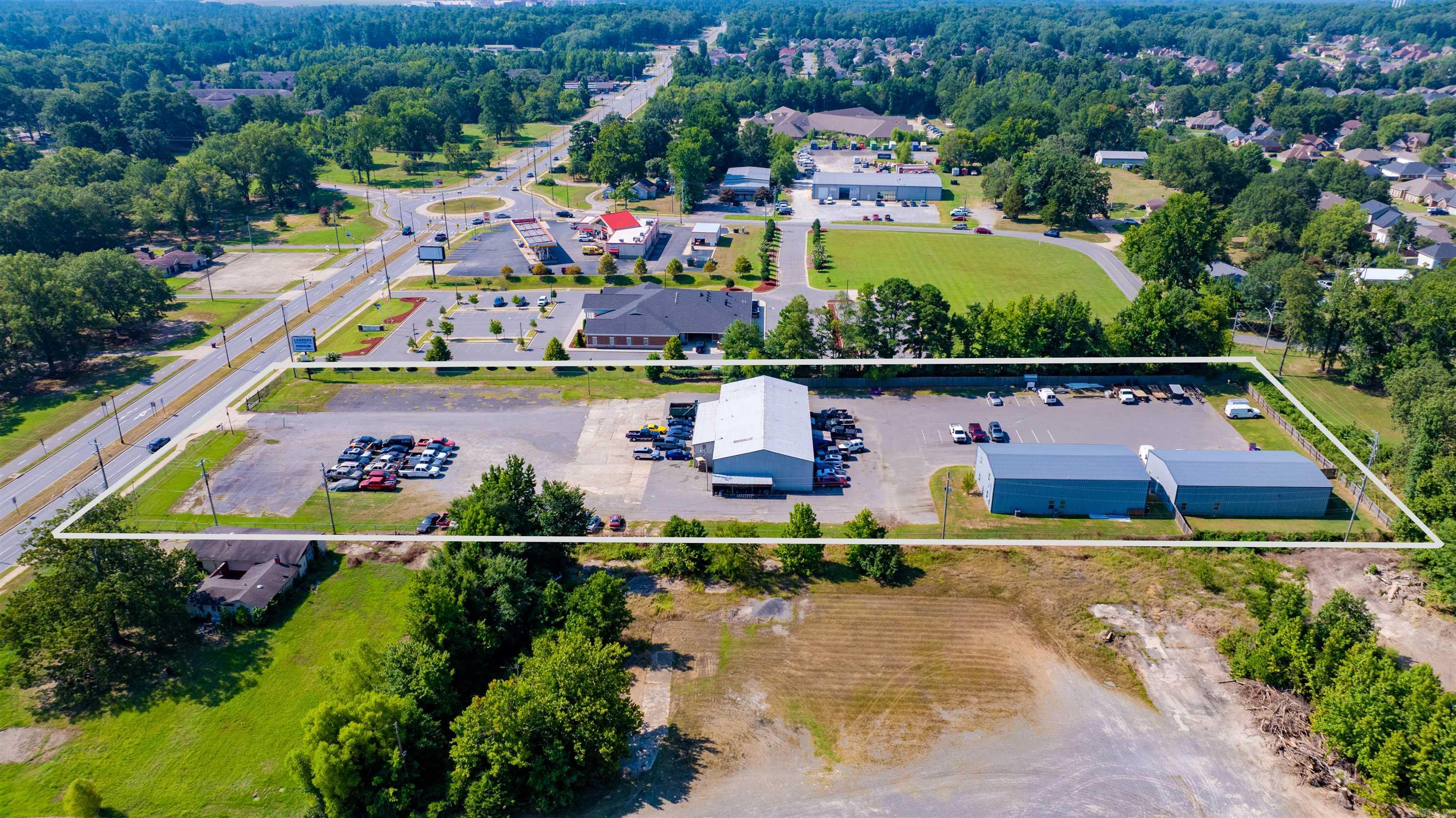 Excellent opportunity to own 3 +/- acres in a rapidly growing area nestled conveniently at the Benton/Bryant line. This level acreage has an average daily traffic count of 13,000 and is in close proximity to neighborhoods, schools, shopping, and restaurants. There are three large buildings, all with ample parking. The front building is a warehouse with 5 garage bays, as well as office space downstairs, and an upstairs apartment and/or office. The second and third buildings, built in 2018, each have 2 garage bays. These two buildings have office space, conference area, kitchen, and bathroom downstairs. Upstairs, the possibilities are limitless, with suitability for an apartment or office/flex space.