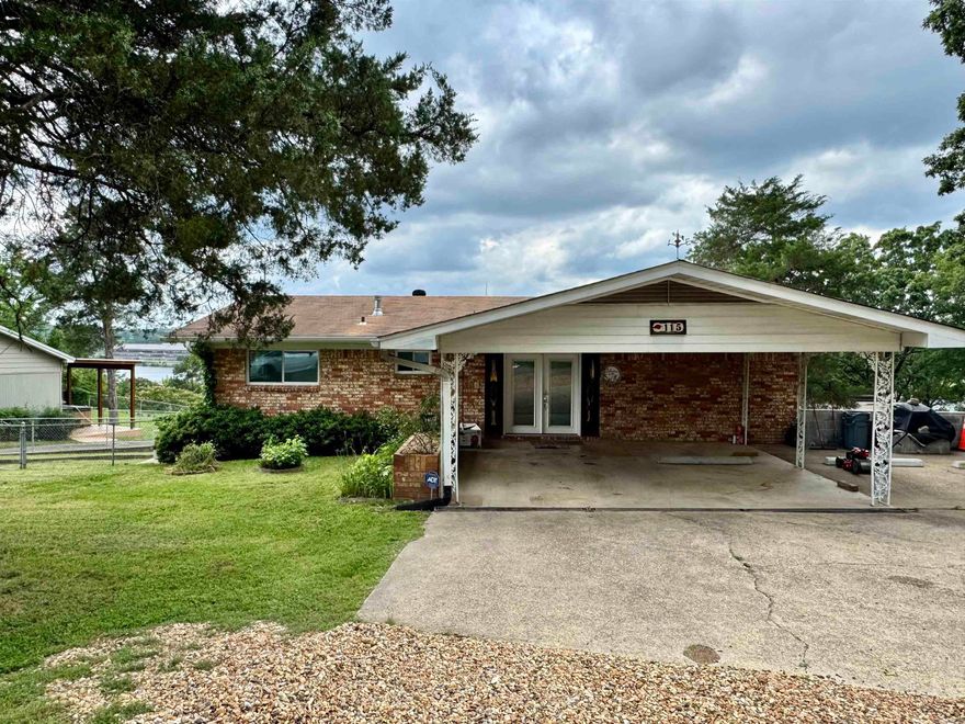 The lake is calling!  Spacious and updated, this Lake Hamilton home is move in ready.  The open lake views will not disappoint.  This home was updated in 2023 and has a history of both short and long term rentals.  Featuring two levels with living rooms on both levels, 2 bedrooms, 1 full bathroom and kitchen upstairs and 2 bedrooms, 2 full bathrooms and a wet bar downstairs.  This home is designed to accommodate guests.  The outdoor space is abundant with a large covered deck upstairs and a screened in covered patio below.  The single stall boat dock sits along the 95 feet of shoreline. Selling fully furnished. Covered 2 car carport.  Bring all offers!