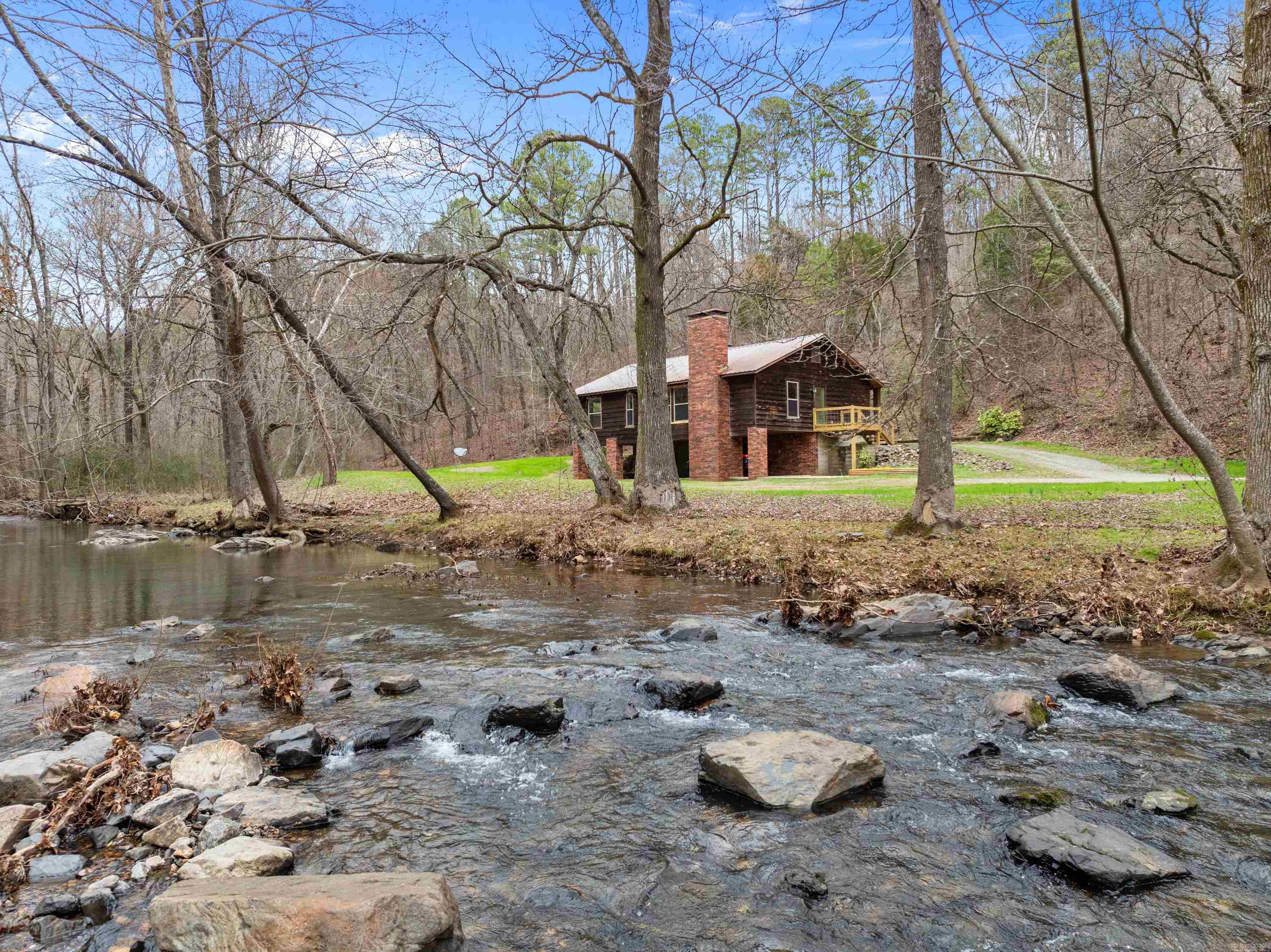 Discover a charming retreat nestled along the pristine banks of Cove Creek, where tranquility meets convenience. This welcoming home offers 3 comfortable bedrooms & 2 well-appointed bathrooms, creating the perfect balance of space & comfort for both full-time living or a promising short-term rental opportunity. Step inside to find a welcoming interior where a cozy fireplace serves as the heart of the home, perfect for those crisp mountain evenings or creating memorable family gatherings. The property's location is truly exceptional, offering the perfect balance of seclusion & convenience. For the savvy investor, this property presents an exciting opportunity as a potential short-term rental, capitalizing on Arkansas's growing tourism market. The creek frontage & private setting create an appealing retreat for those seeking a genuine Natural State experience. Whether you're looking for a permanent residence or investment opportunity, this home offers the rare combination of waterfront living, privacy, & practical amenities. The natural beauty of Cove Creek, combined w/the home's comfortable living spaces, creates an irresistible package for those seeking their own piece of paradise