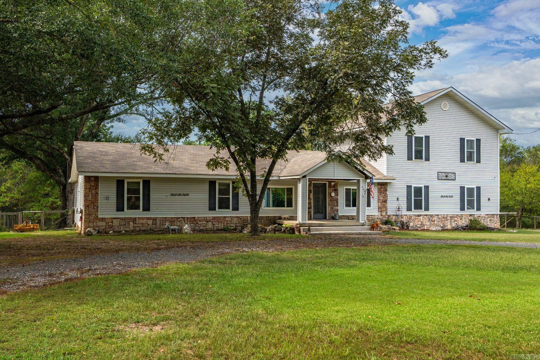 Horse-ready 5.08-acre property in Hot Springs with everything you need for country living! This beautifully remodeled 3-bed, 3-bath home offers 2,542 sq. ft. of updated space with luxury vinyl and tile floors throughout—no carpet! The spacious kitchen features custom cabinets, granite countertops, double sink, electric range, oven, dishwasher, and pantry. Above the garage is a versatile mother-in-law suite with a private entrance, previously rented as an efficiency apartment for $750/month. It’s perfect for guests, rental income, or multi-generational living. Bring your horses! The property includes a 1,260 sq. ft. barn with two stalls, a pond, garden area, chicken coop, and a fenced dog run—everything you need for a hobby farm or peaceful rural lifestyle. Relax on the front porch, back patio, or around the firepit. Private and peaceful, yet just minutes from all Hot Springs amenities. Whether you're dreaming of a mini farm, a horse haven, or just a quiet retreat, this property delivers. It truly feels like you're miles away from the city, yet you're close to everything Hot Springs has to offer.