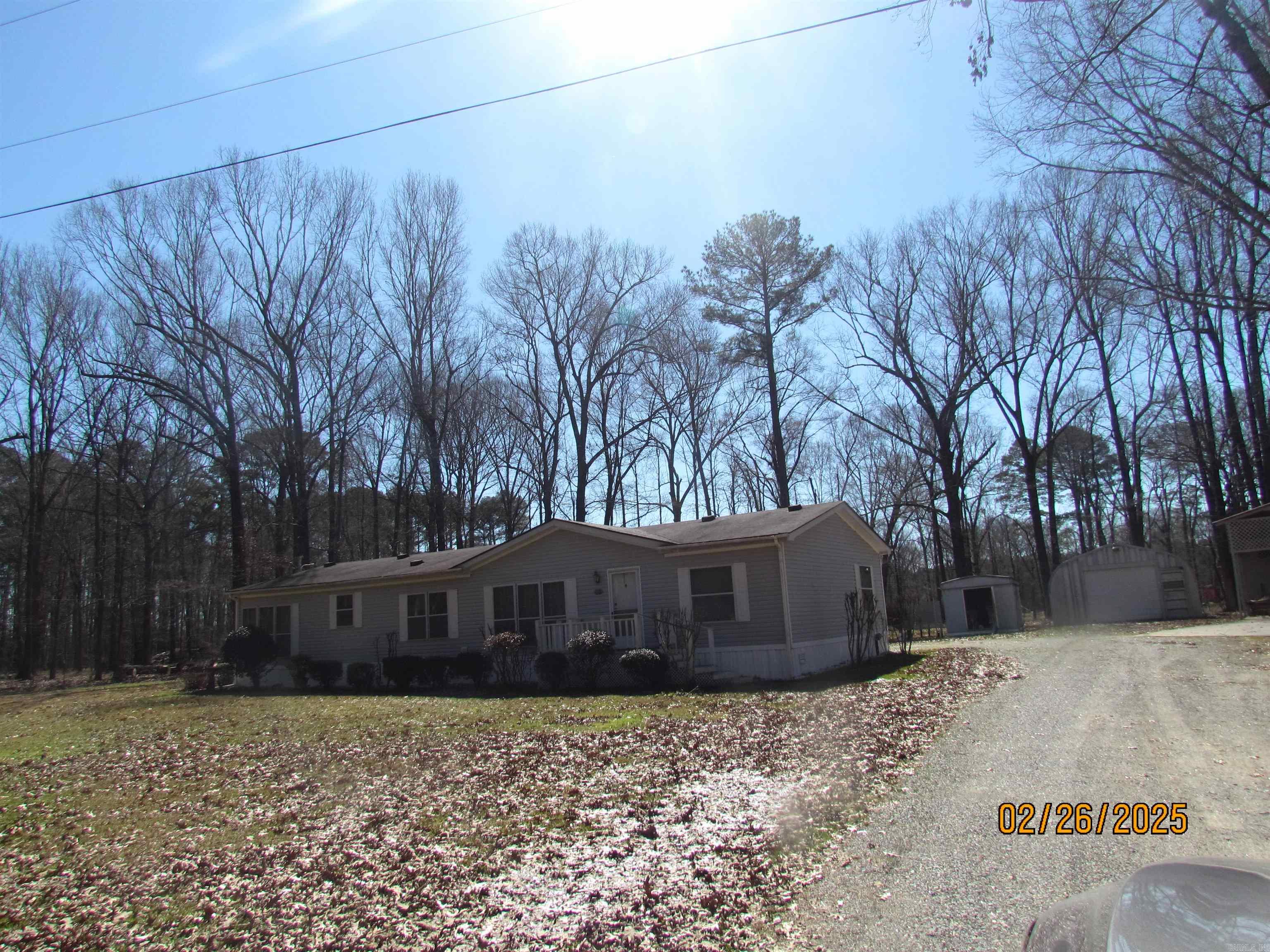 This lovely property is a country get away. It features a back porch just waiting for rockers and bird feeders, a deck for cookouts, and 3 acres of yard for wildlife to come and visit. The lovely manufactured home features two living areas, one a formal living room open to the formal dining area, and a den with windows on two sides that invites outside scene inside. This is a great room. It is open to the Breakfast area which also has windows on two sides and a door leading to the side porch. The kitchen has lots of cabinets, a breakfast bar, dishwasher, stove and the refrigerator remains. Home features 3 bedrooms, hall bath with shower over bathtub and the large master bedroom has double doors leading to the large master bath with walk-in shower and a garden bathtub. The laundry room has room for a freezer and has a door leading to the back porch and deck. A double carport connects to the back porch and it has a steel shop, storage building , and a RV shed with storage in the back. The property sits on 3 acres of land with lots of privacy. This is one you must see to know all the amenities for this property. Pictures of interior coming after estate sale.