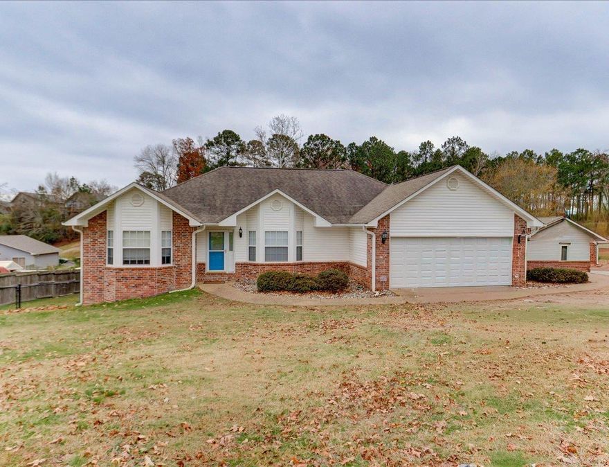 Lake Hamilton living at its best in the Lakeside School District. This beautiful 3-bedroom, 2.5-bath home offers the ease of primarily one-level living, paired with the lifestyle only lakefront can provide.  Enjoy peaceful lake views from the covered deck overlooking Lake Hamilton, just steps from your covered boat dock with lift—perfect for days on the water and relaxed evenings at home. The main level features a private and spacious primary suite with an adjoining office area, along with a well-appointed ensuite bath complete with a jetted tub and walk-in shower.  The lower level adds exceptional flexibility with a heated and cooled bonus space, currently used as a workout room and ideal for a fourth bedroom, office, or recreation area. This level also includes a convenient half bath and is fully incorporated into the home’s total square footage—often referred to as the ultimate man cave.  Additional highlights include a two-car garage, covered carport, and a storage shed to accommodate vehicles, lake toys, and equipment with ease.  A thoughtfully designed home that blends comfort, functionality, and true lakefront living