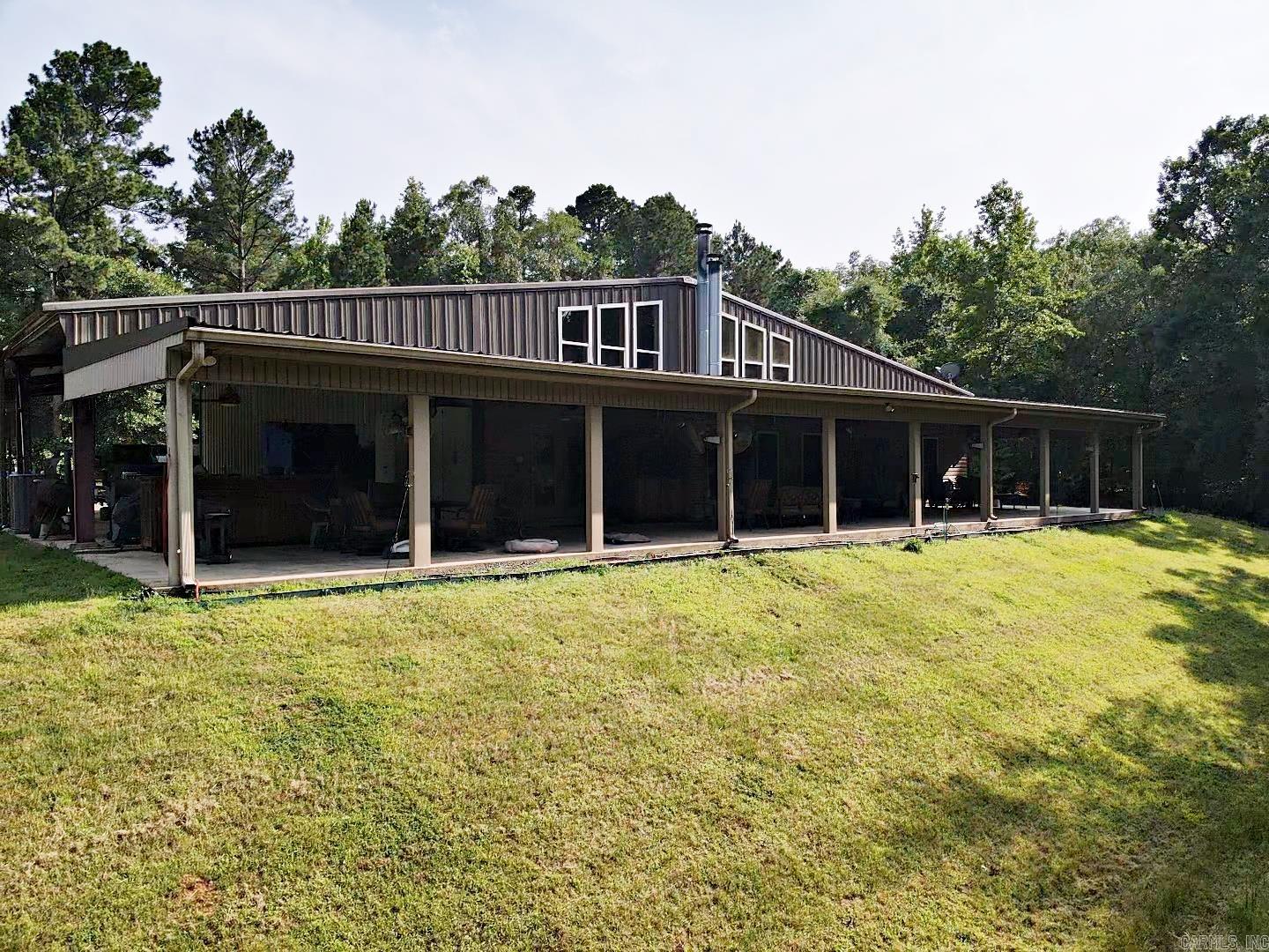 This is a luxury, one-of-a kind Barndominium sitting on 8.02 acres, minutes from Lake Degray. It has over 3,000 sq ft living space plus a large shop all under one heated and cooled roof. Also under this roof on the outside are two covered carports and a large porch that spans across the back with an outdoor fireplace and living space. There is also a large one bedroom one bath upstairs with a beautiful view. Storage is bountiful with a large laundry room and closets on both levels. There is also a hidden closet, a 25KW Diesel generator and a 38 X 58 RV Shop are only a few of the extras on this property. It is a must-see property. Schedule an appointment today, this one will not last long!