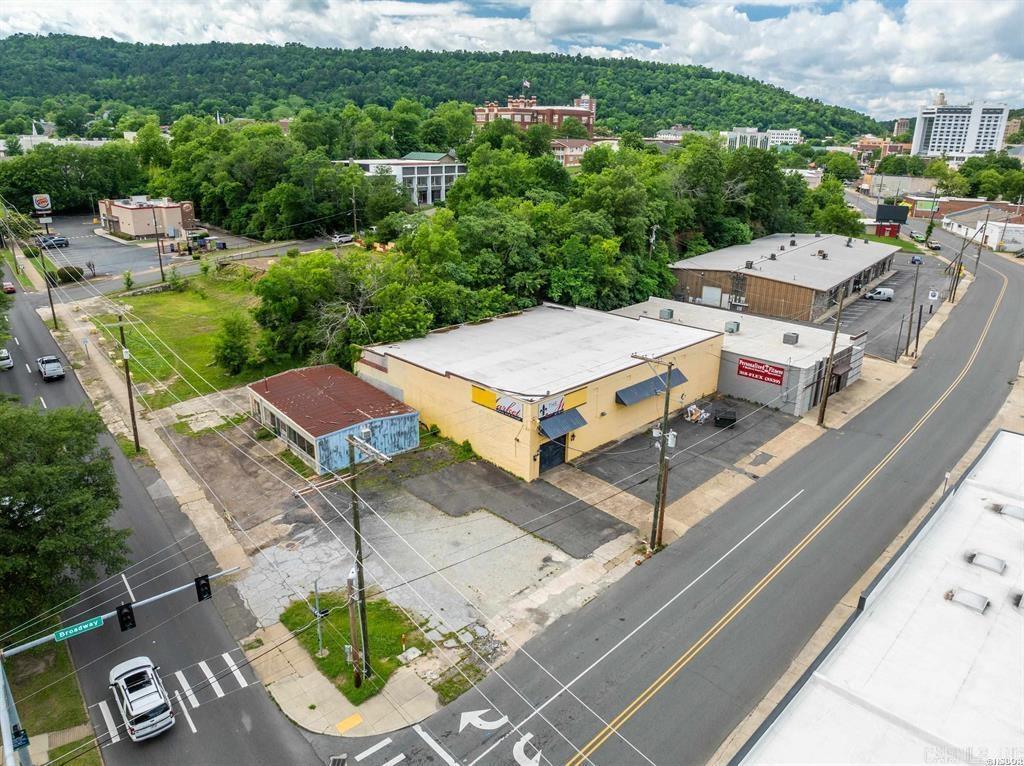 This historic property, located at 454 Broadway Street and 208 & 214 West Grand Avenue in Hot Springs, Arkansas, offers over 8,000 square feet of versatile commercial space on just over one acre of land. Built in 1939, the main two-story building exudes timeless charm with original cut redwood construction and expansive interiors that are ideal for a range of uses, including boutique hotel, retail, office, or entertainment venues. Zoned C1 and situated within a Federal Opportunity Zone, the site provides significant investment advantages. The property boasts a combined 620 feet of road frontage, including an impressive 307 feet along high-traffic Grand Avenue, which sees approximately 20,000 vehicles per dayāensuring maximum visibility and accessibility. Located just steps from major hotel chains and the vibrant downtown district, this site is strategically positioned in one of Hot Springs' most desirable and high-demand development corridors. Whether youāre a developer or investor, this is a rare opportunity to revitalize a landmark building in a prime, high-exposure location. Great Owner Finance Opportunity!
