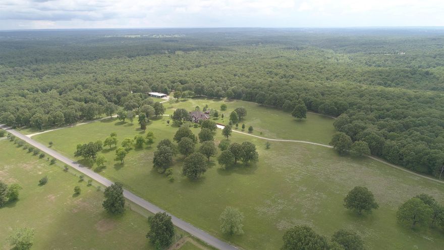MOTIVATED SELLER! Seller will entertain ANY offers or Deals. Set among 20+/- acres of beautiful rolling pastureland, this 10,000+ sq ft custom built home is a dream property.  The 3-level all-brick home features 7 bdrms, 5 full & 3 half baths, 3 full kitchens & a laundry room on each floor, 6 gas log fireplaces & double garage. The front entrance leads to a spiral staircase where guests pass under an elegant chandelier set beneath a grand dome, before entering the formal living room featuring cathedral height ceilings. Main floor also contains a formal dining room, custom wood paneled oval office & guest suite with full bath, large custom kitchen, informal living space, breakfast & mud/laundry room w/half bath. Main floor master suite includes his & her full baths & large shared walk-in closet. The second floor has two full baths & three guest rooms with one featuring its own living area, fireplace, full kitchen & laundry.  The basement has a full kitchen & laundry, two bedrms, 1 full bath, & 1  half bath w/separate handicap accessible walk-in shower.  An elevator services all three floors. The property also contains a garden house & whole house propane generator.
