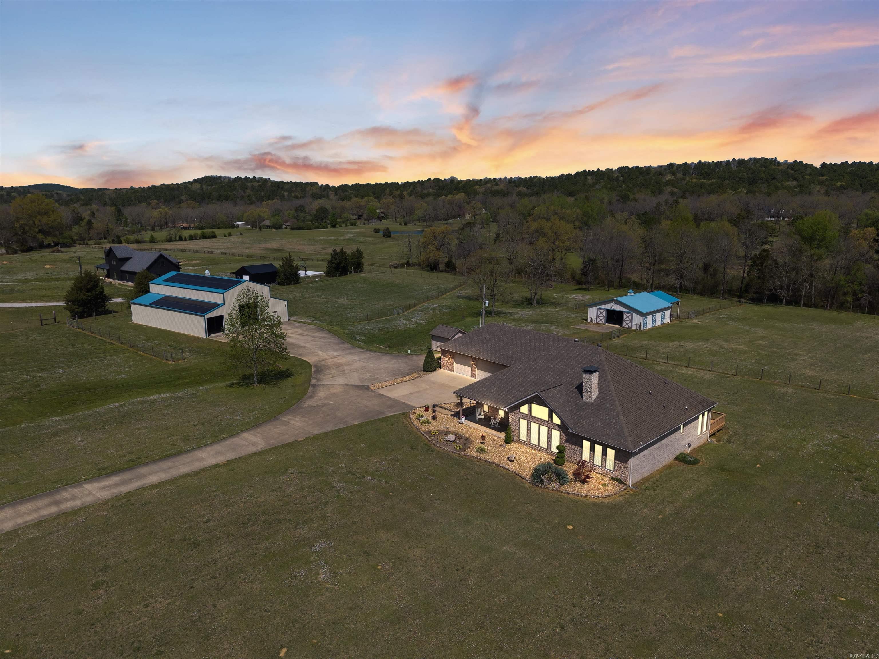 Welcome to peaceful country living on 11 incredible acres with a private gate and fully fenced with sub-fencing. Beautifully renovated one-story home features 3 bedrooms, 2 full bathrooms, an office (or 4th bedroom), sunroom, FEMA-rated safe room, and a 3-car garage. The open-concept great room boasts a vaulted ceiling, fireplace, hardwood floors, built-ins, and a gourmet kitchen with high-end appliances, quartz countertops, walk-in pantry, coffee bar, and wet bar with ice machine. Kitchen appliances include a Thermador Induction cooktop, dishwasher drawers (2), built-in refrigerator and freezer, microwave drawer and double wall ovens. The spacious primary suite includes dual closets and a spa-like bath. The 3,780 sq ft shop offers a kitchenette, full bathroom, laundry service, and space for RVs/cars, hobbies such as pickleballāpowered by 66 solar panels keeping electric costs under $15/month for the entire property. The barn includes 3 stalls (with 2 more available), a tack room, and lean-to for equipment. A new well house is in place, with city water expected soon. Comfort, efficiency, and wide-open space all in one!