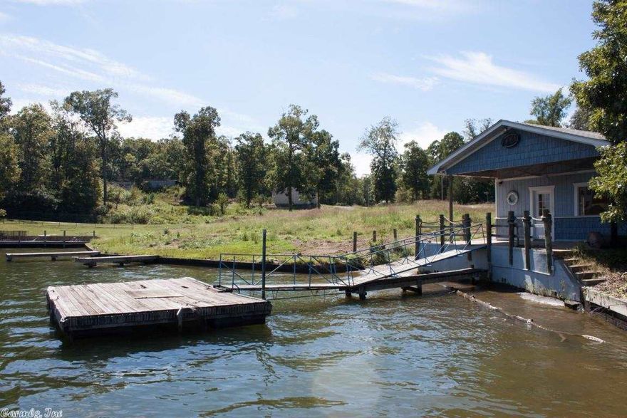 Formerly a marina.  This lot has a shop in place.  Entergy says no more marina that sells gas, but a great place for a home site or other lake business.  There were never underground gas tanks.  The land is clean and ready for a build.  Appraisal says 255' of frontage & .9 acres.  1590sf shop is still on property.  Rural water on property as well as septic and electric.  Boat ramp.  3 piers, 1 dock.  Bring all offers!